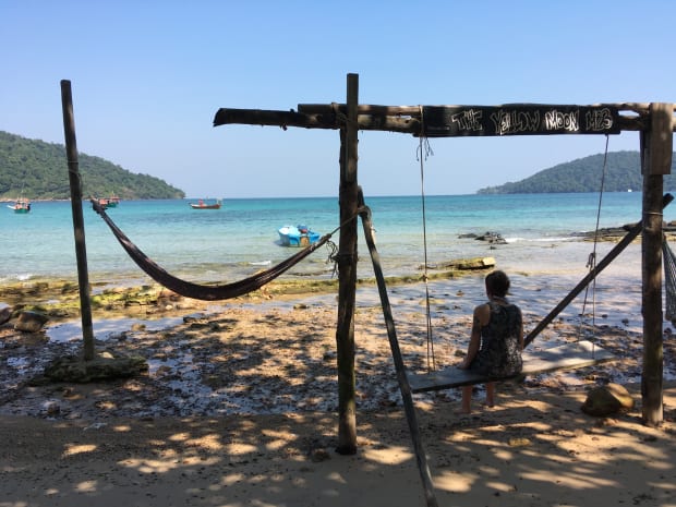 Rosalie sitting on a swing on the beach