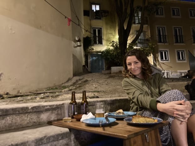 Rosalie enjoying more vegan good on the steps at The Food Temple in Lisbon