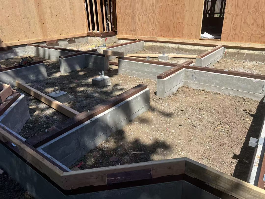 Worker framing exterior wall on slab