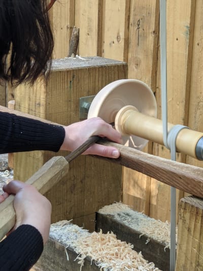 Turn a wooden bowl outdoors on a foot powered pole lathe