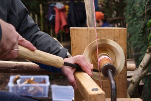 Turn a wooden bowl outdoors on a foot powered pole lathe