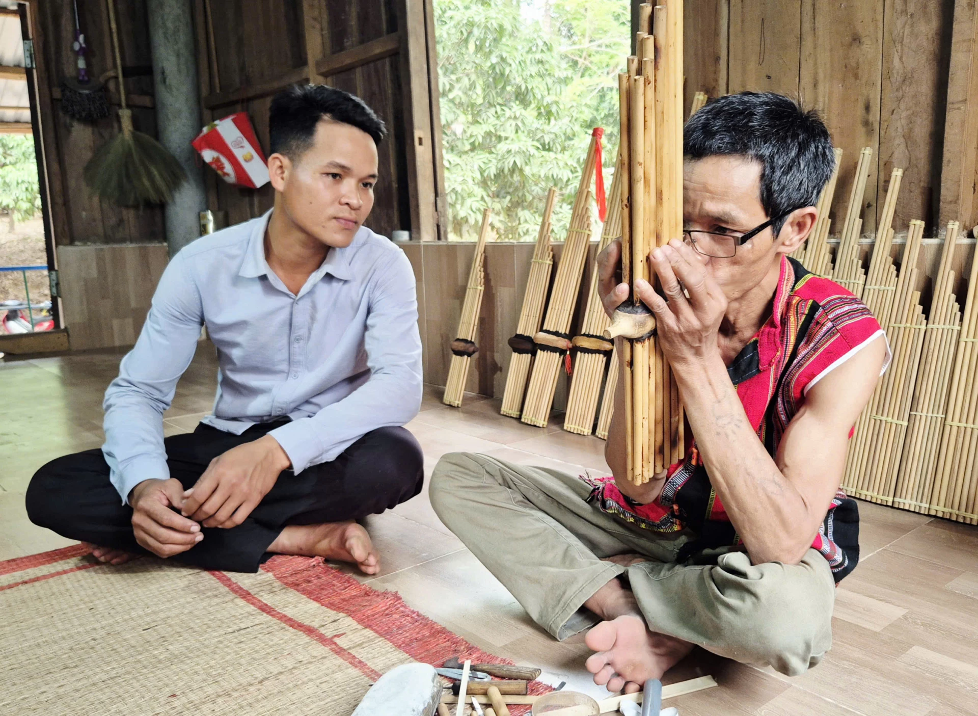 Nghệ nhân Pả Hơi (phải) tận tâm truyền dạy kỹ thuật sử dụng khèn bè cho lớp trẻ - Ảnh: K.S