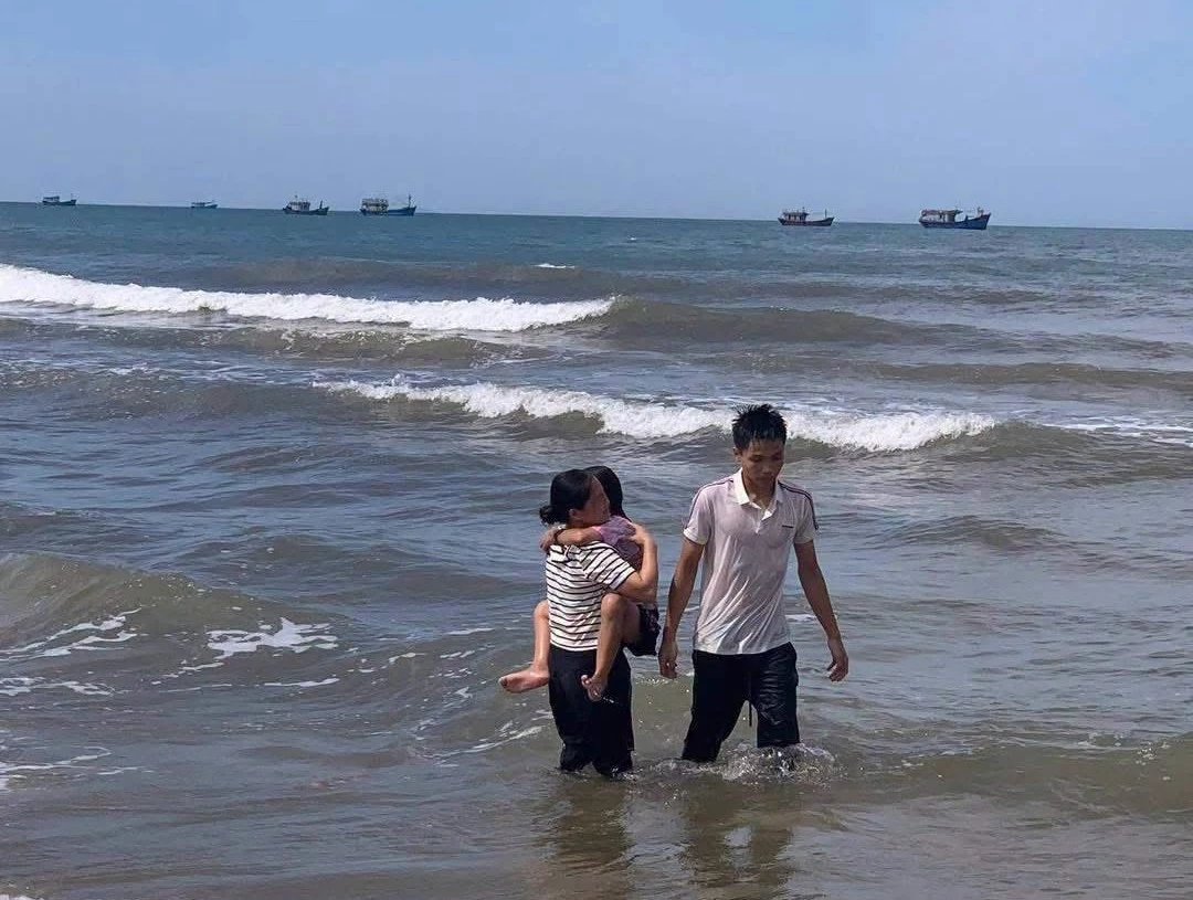 Bé gái bị sóng cuốn được nam sinh cứu đưa vào bờ - Ảnh: N.M.P