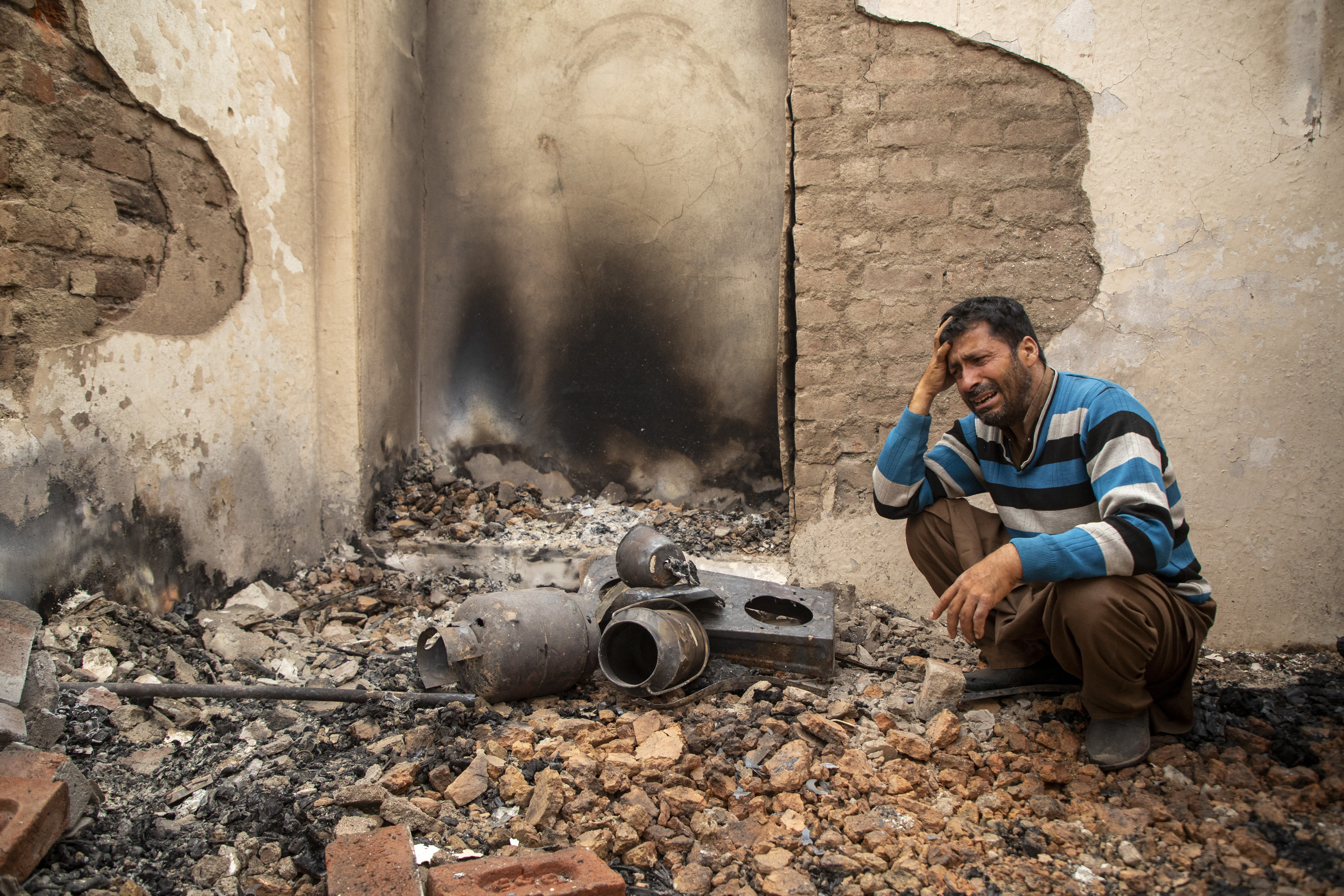 A Kashmiri resident reacts to his damaged house following cross-border shelling in Salamabad, a village near the Line of Control in Uri, Indian-administered Jammu and Kashmir