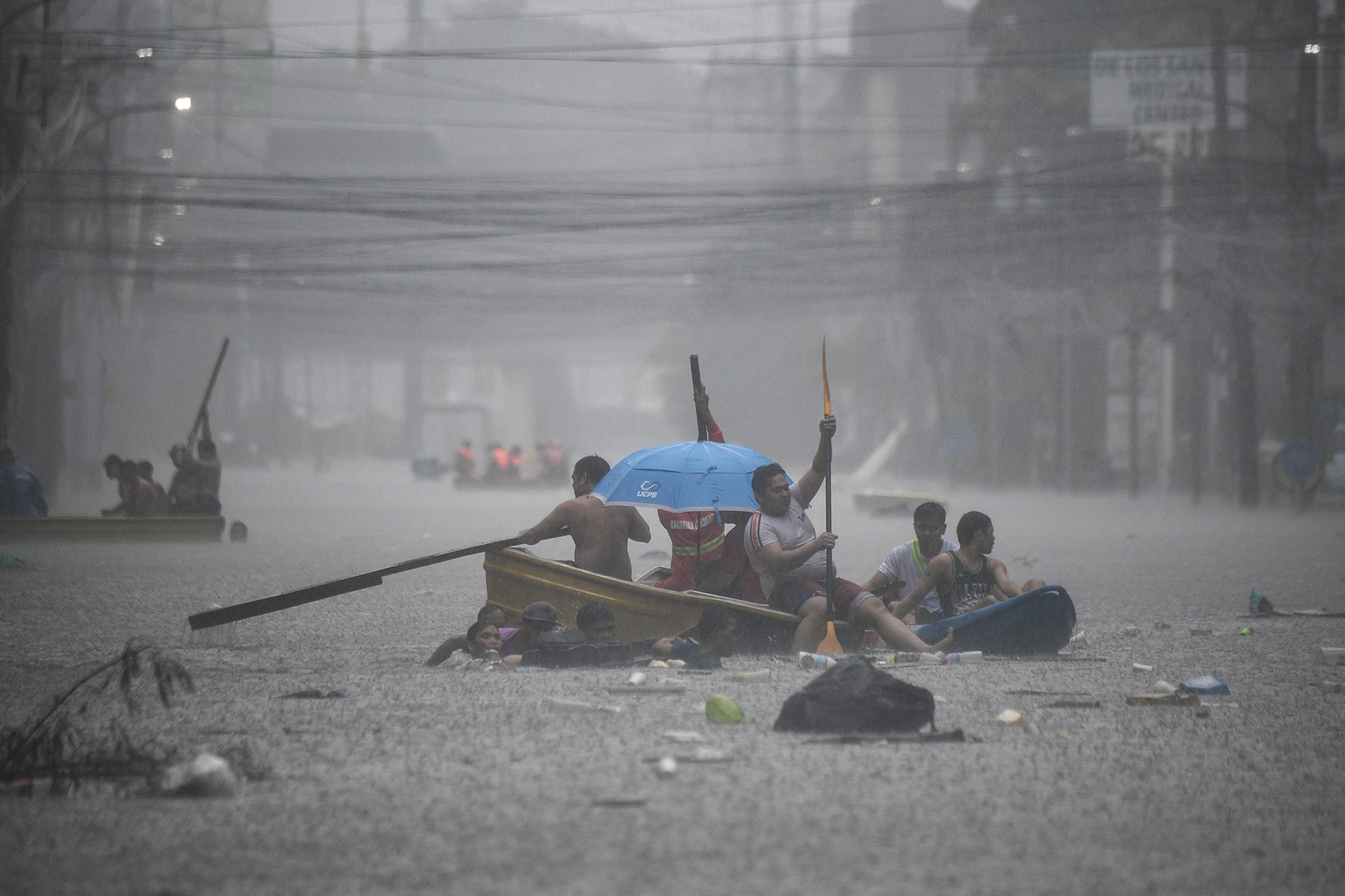 Rescuers paddle their boats along a flooded street in Manila.