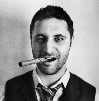 Headshot of John Koht smoking a cigar