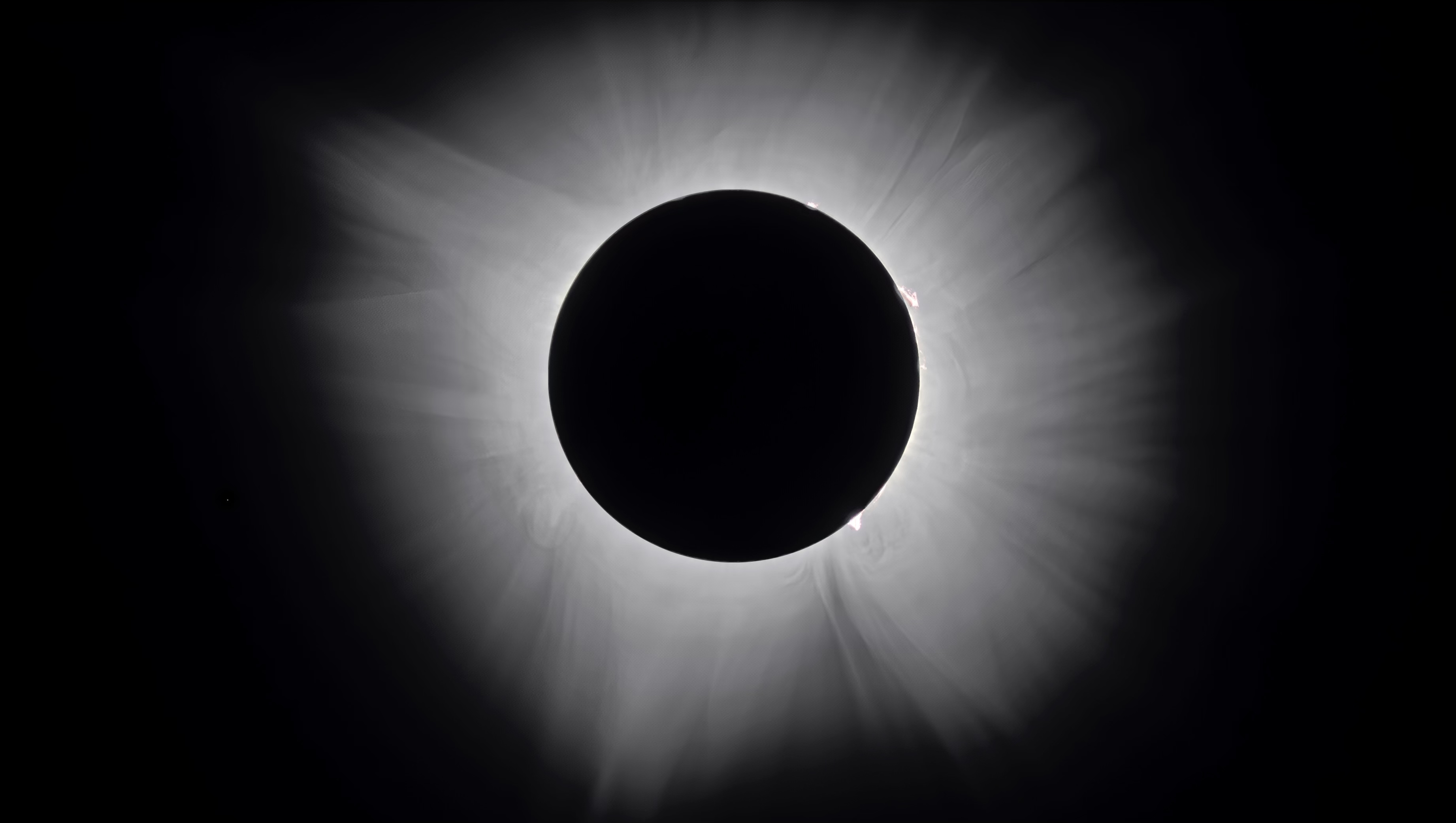 The Sun's pearl-white corona surrounding the black disc of the Moon during a total solar eclipse