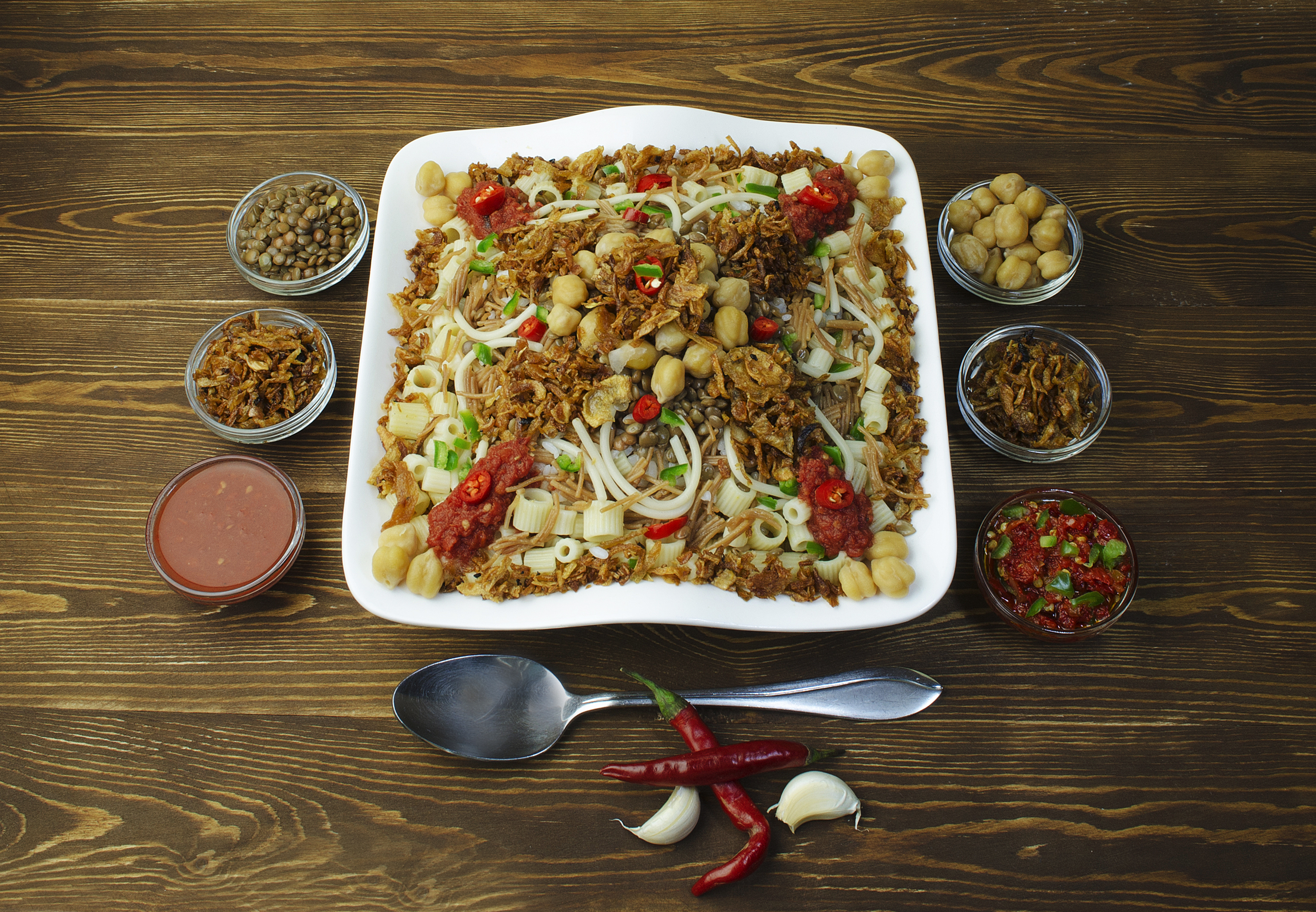 A bowl of Egyptian koshary with rice, lentils, pasta, chickpeas and fried onions