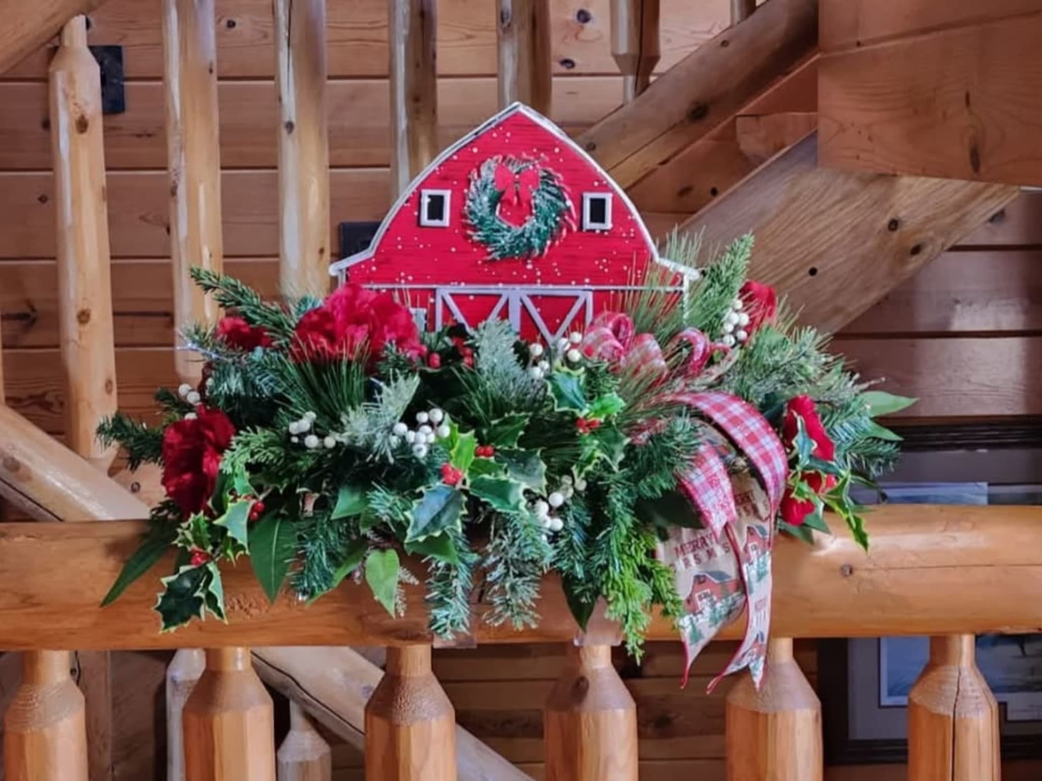 Barn surrounded with flowers and a red plaid ribbon