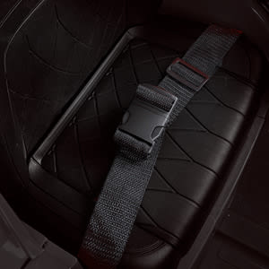 Close‑up of the black automotive safety belt and buckle system against the dark leather or vinyl seat surface.