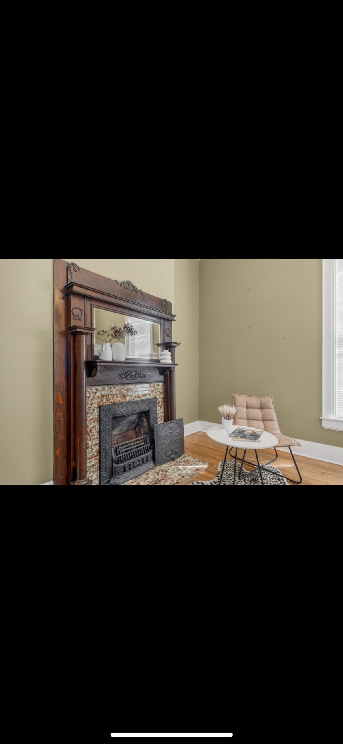 The Parlor before restoration — single chair in a near-empty room with the dark mantel