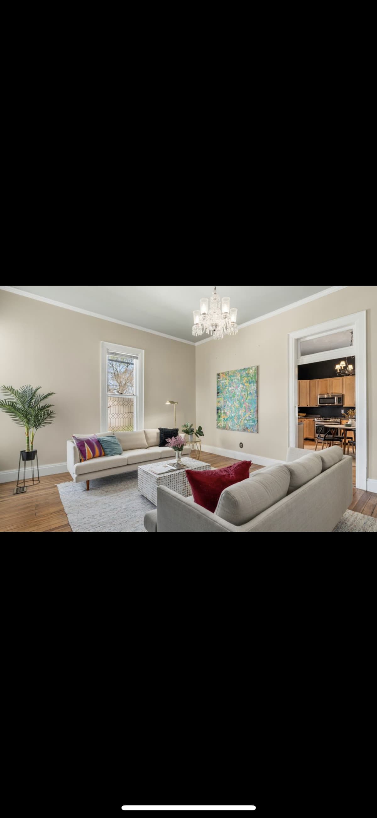 The Living Room before restoration — bare walls and original floors with staging furniture