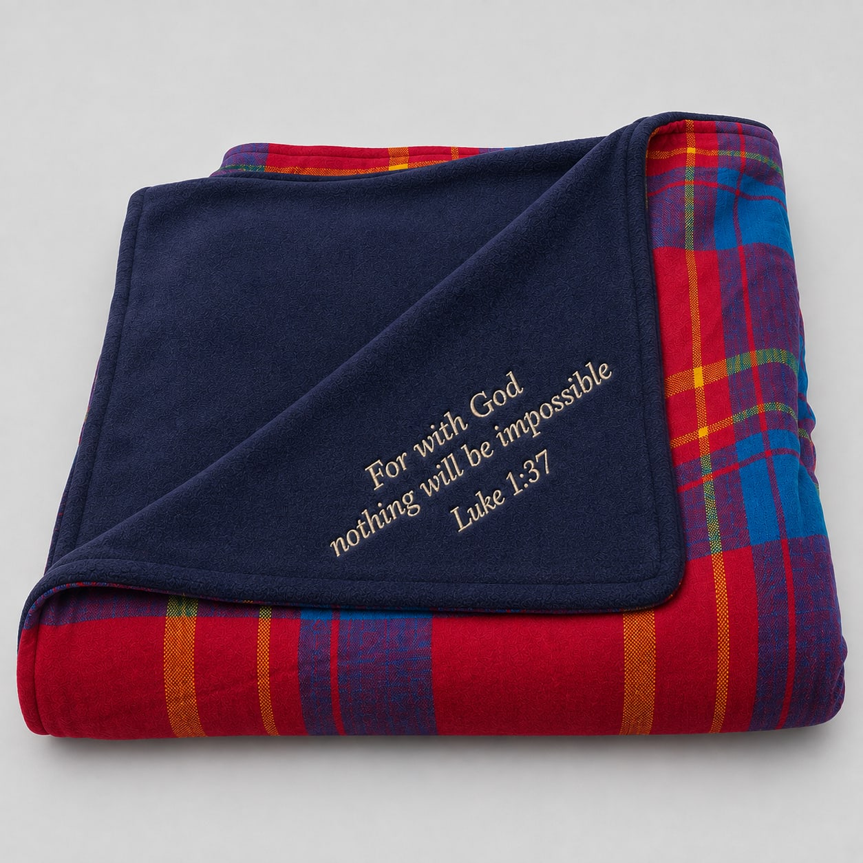 Custom embroidered heavy Maasai fleece blanket featuring red and blue plaid shuka backed with navy fleece and Luke 1:37 scripture embroidery