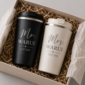 Custom laser engraved matte black and cream thermal travel mugs set for couples personalized with Mr. and Mrs. Warui and wedding date in a gift box.