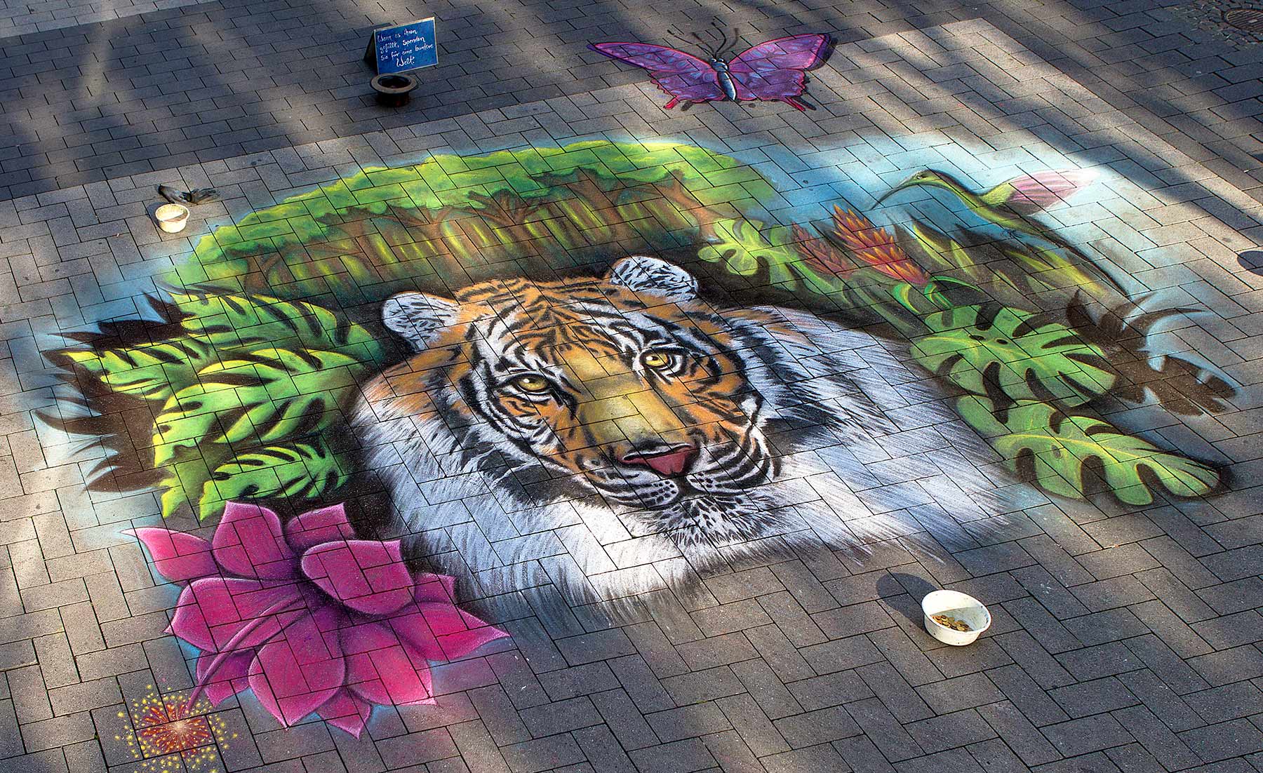 Straßenmalbild mit Kreide auf Pflaster, Tiger als realistische 3D Straßenkunst auf dem Boden