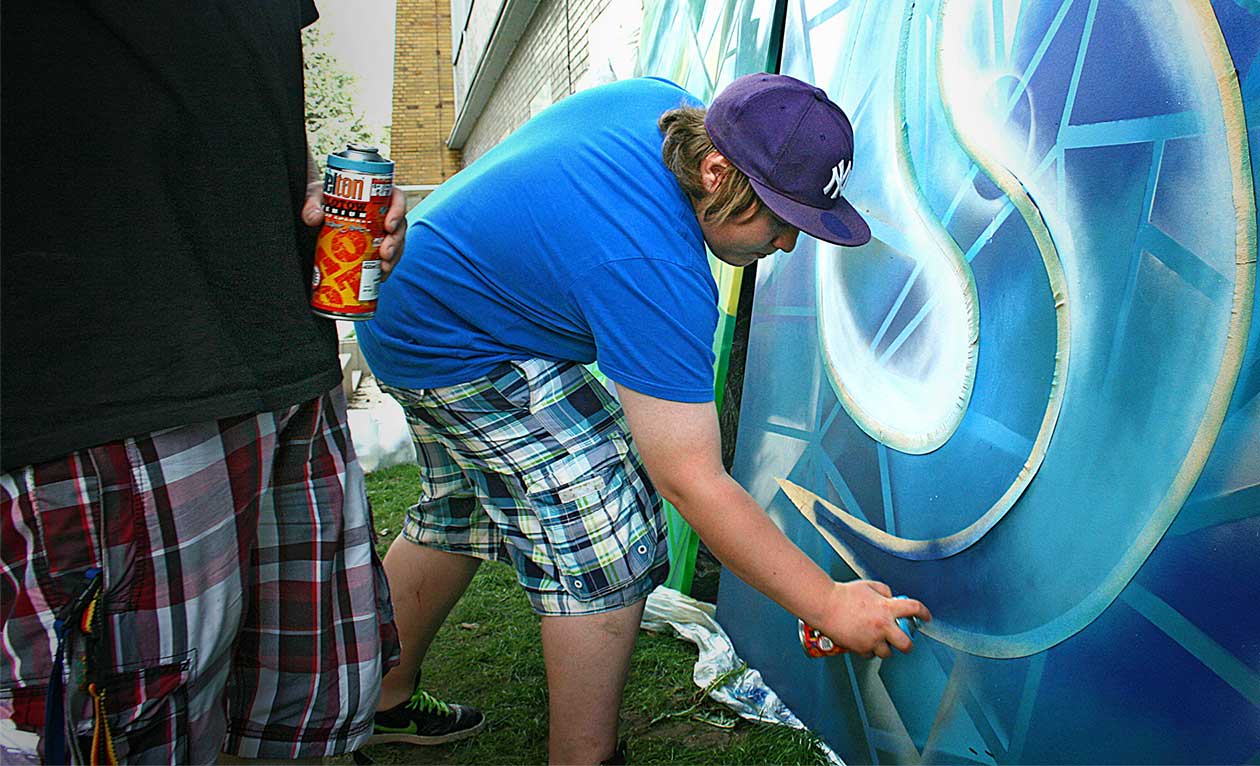 Straßenmalbild mit Kreide auf Pflaster, Graffiti Boy als farbige Straßenkunst