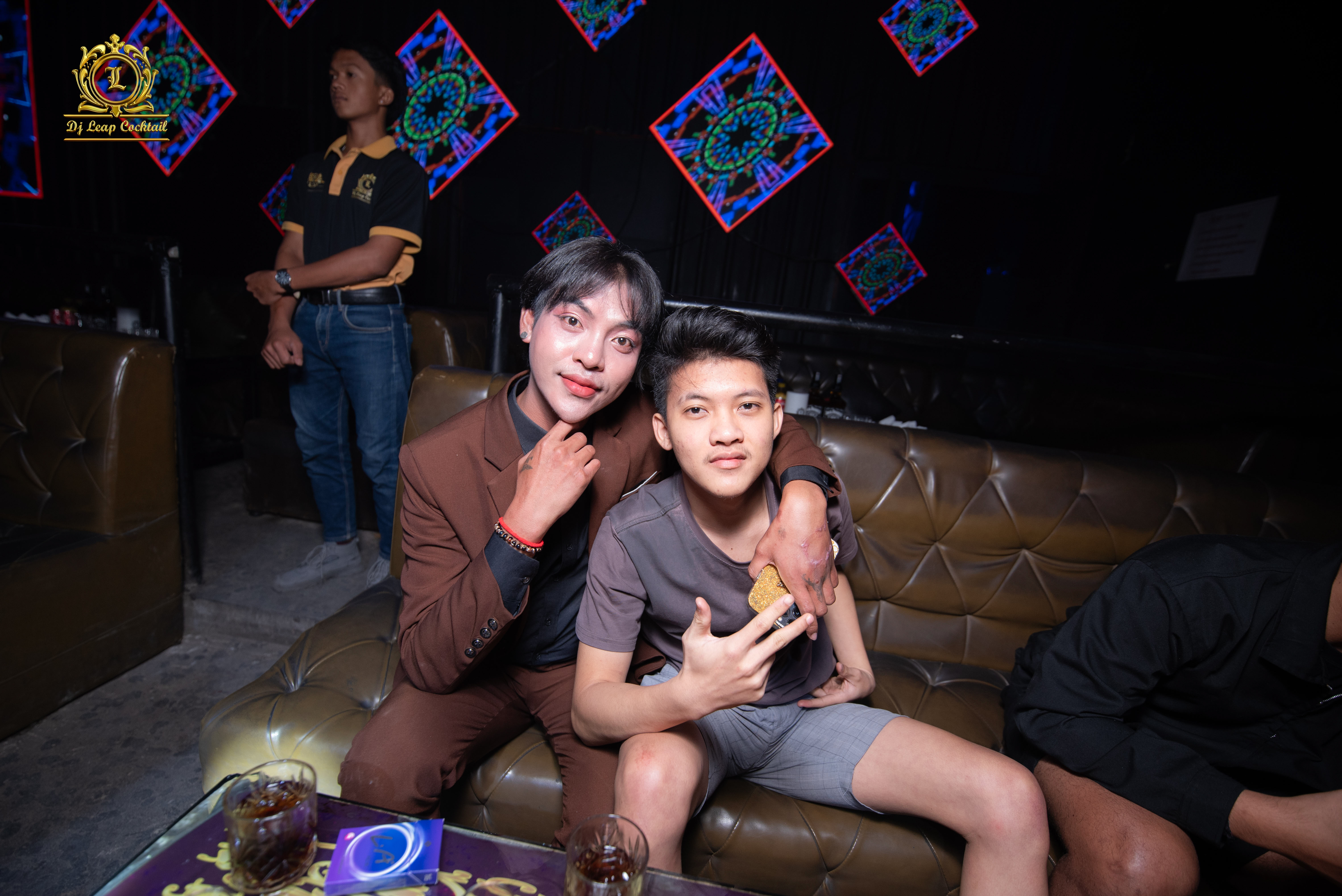 Nanda dan Bencong sedang duduk di kedai kopi saat pertemuan pertama mereka, saling tersenyum dengan latar belakang kota yang romantis