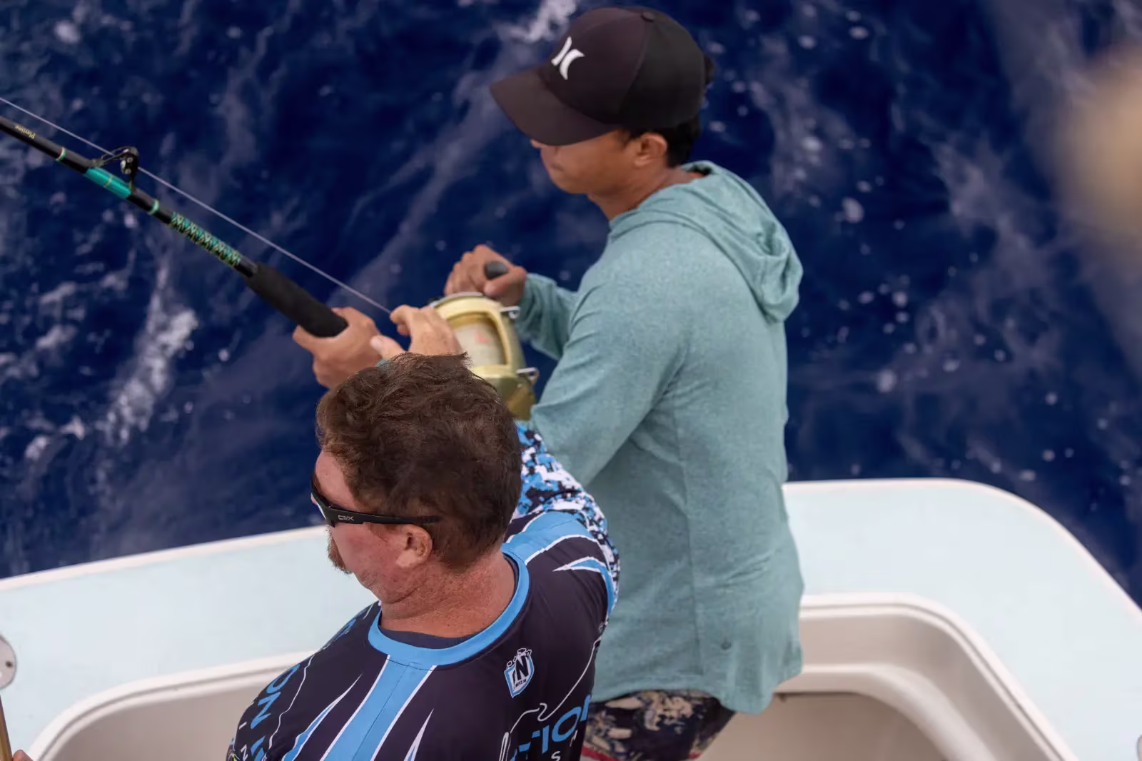 Tourist fighting fish with crew support