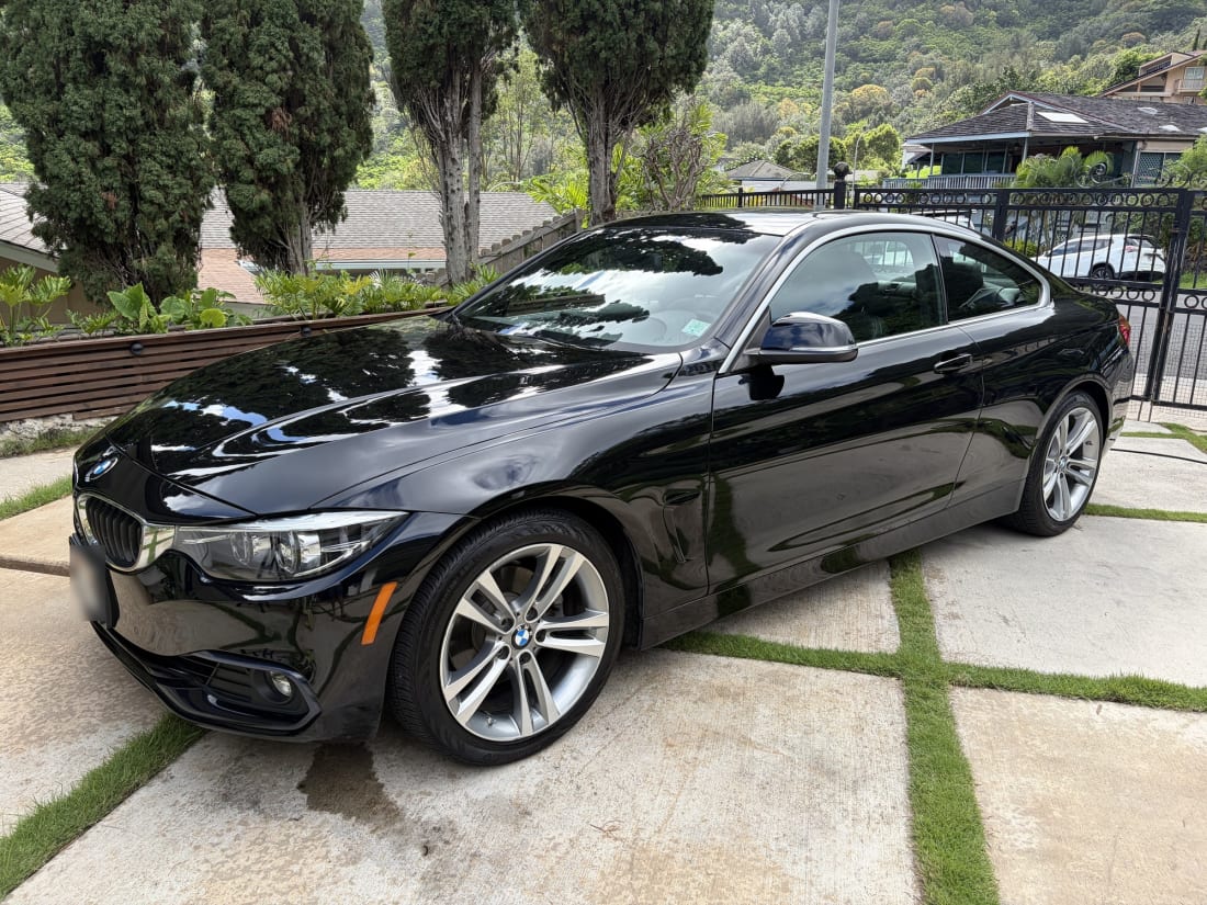 Black BMW 4 Series detailed to a mirror gloss on an Oahu driveway