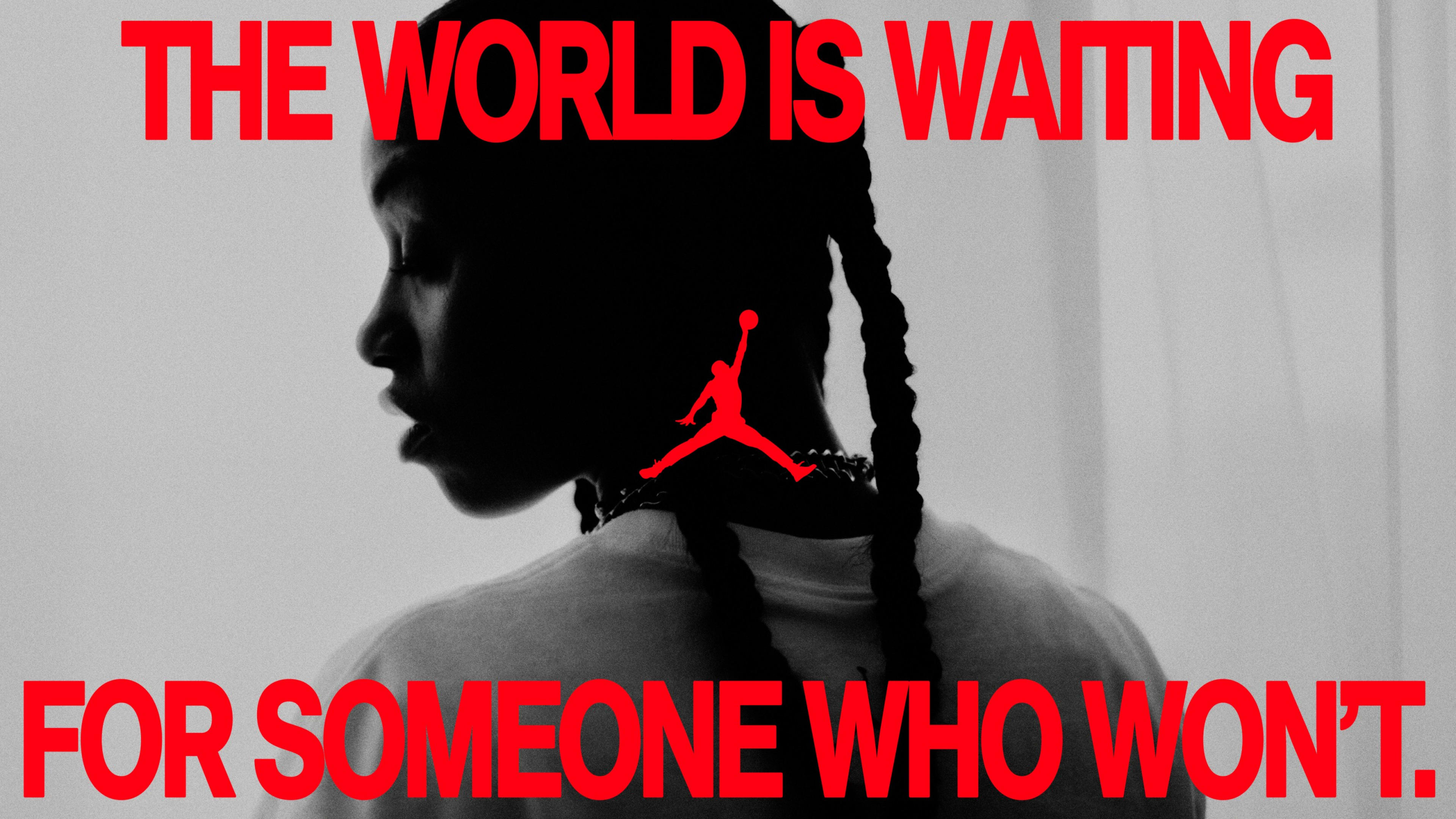 Black and white back angle view of an athlete looking over her shoulder. A caption in red font reads, "The world is waiting for someone who won't." The Air Jordan logo is in the center.