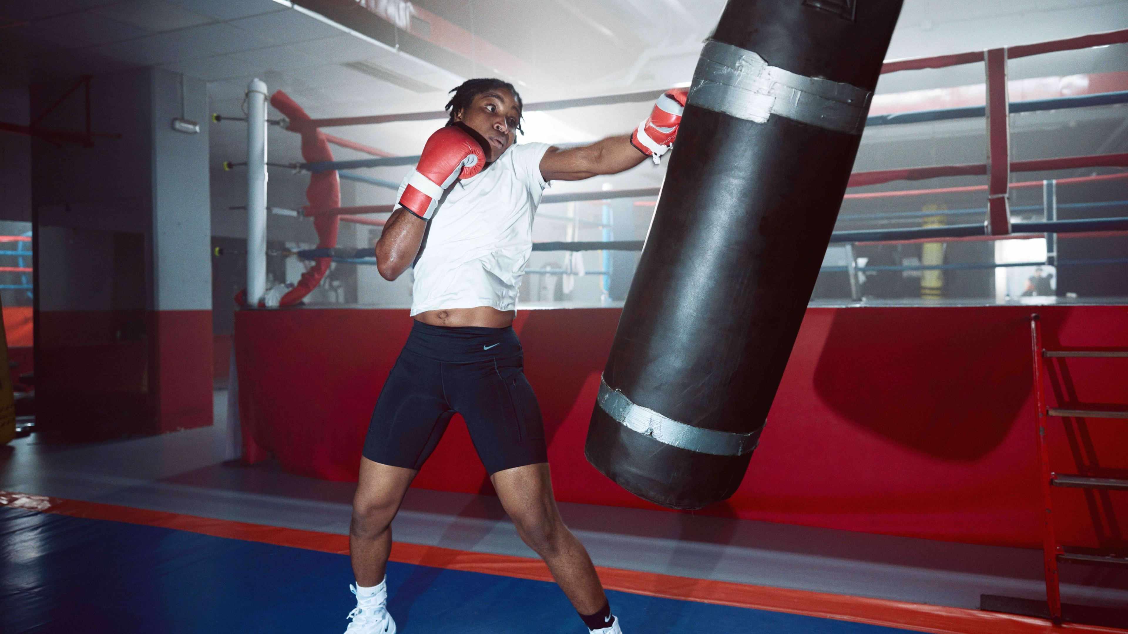 Cindy Ngamba at a boxing gym throwing a left jab at a swinging punching bag.