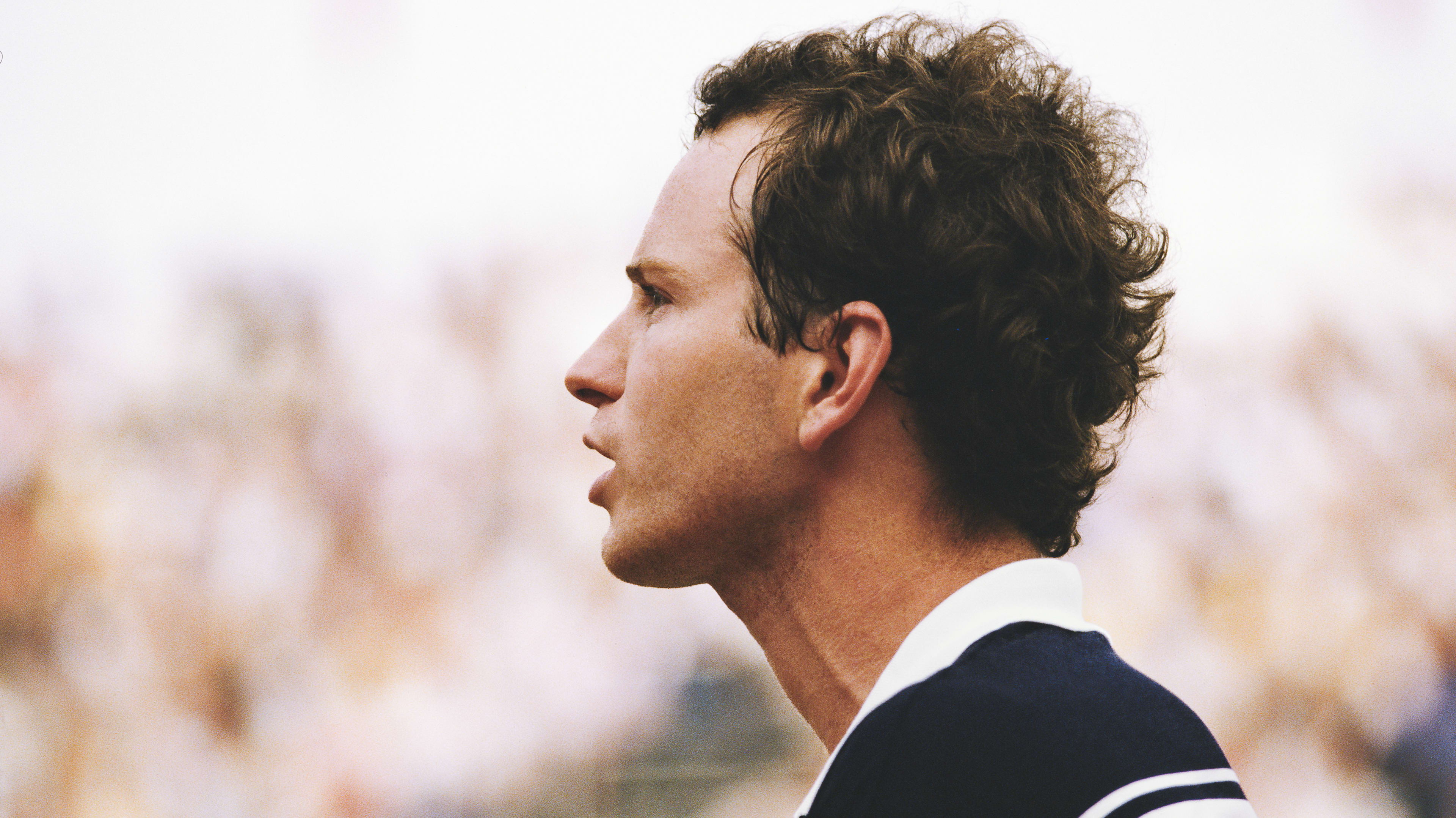 Profile view of young John McEnroe in a speaking pose.