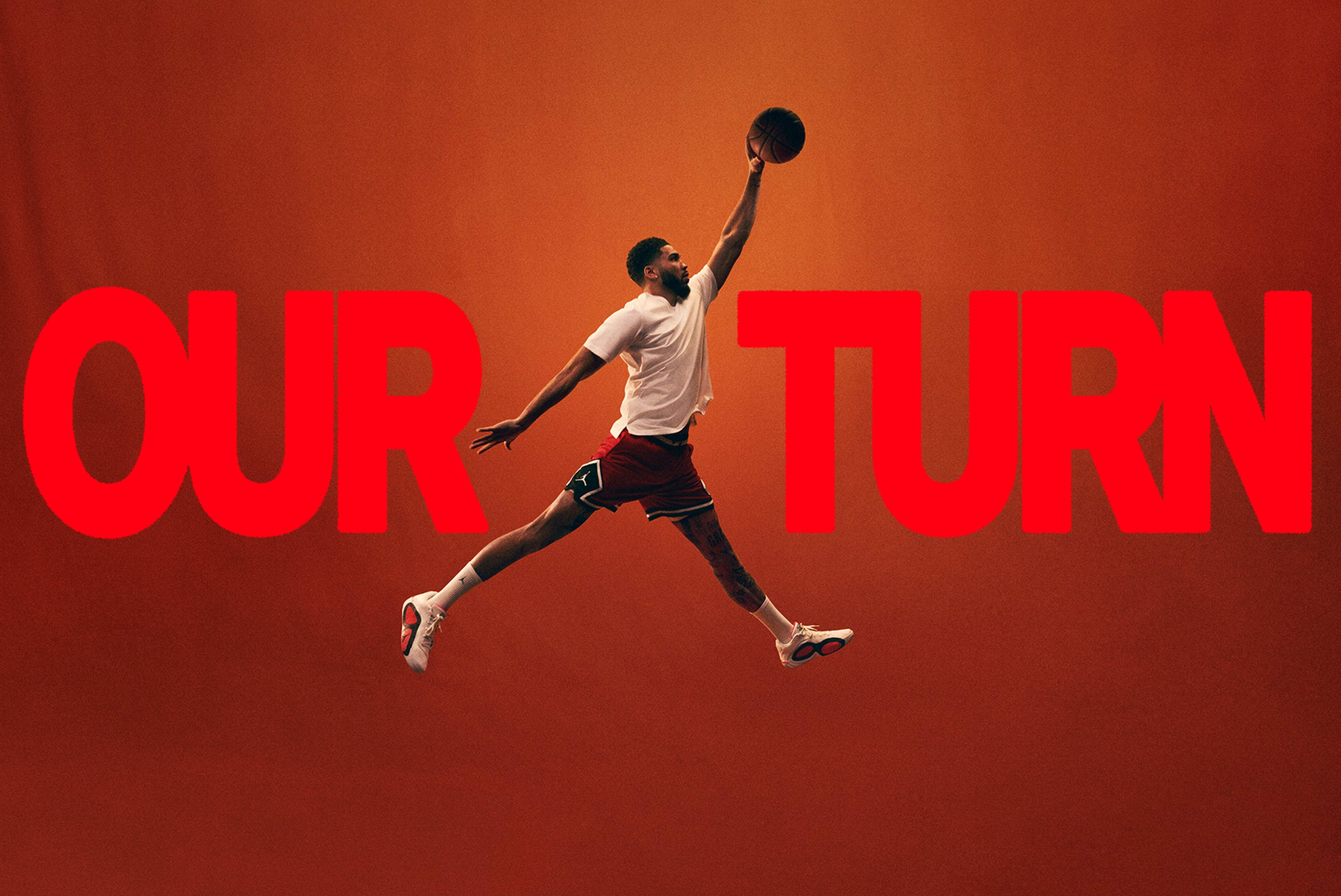 A basketball player striking the Air Jordan dunk pose, centered between the words "Our turn" written in large red font on an orange background.