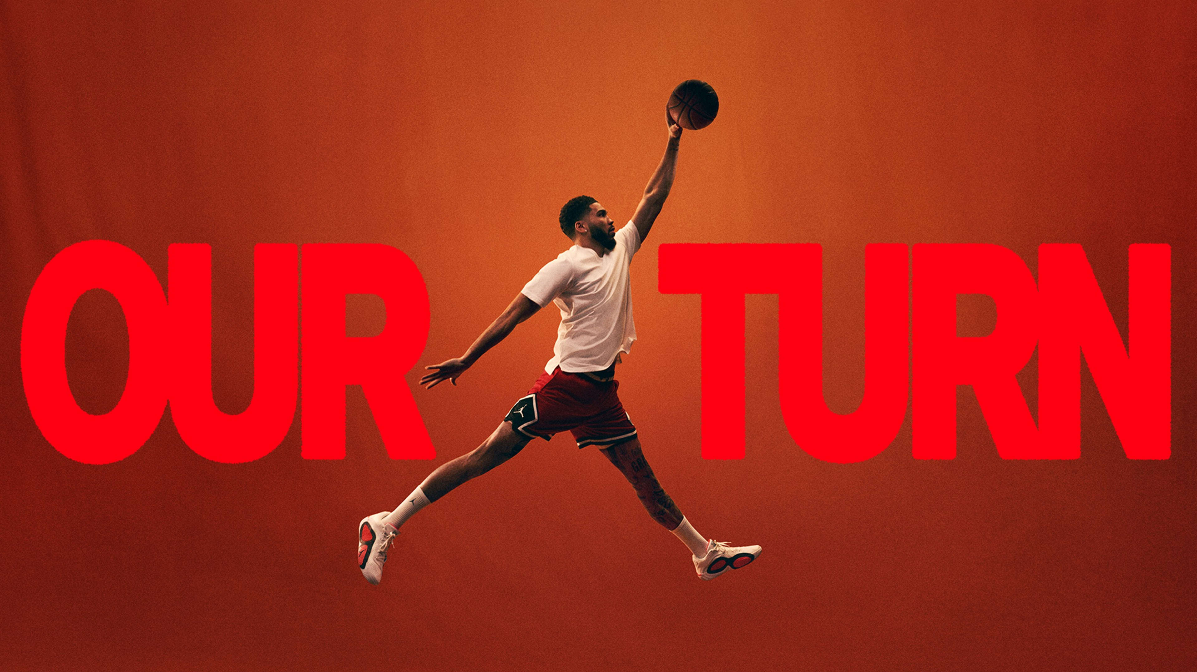 A basketball player striking the Air Jordan dunk pose, centered between the words "Our turn" written in large red font on an orange background.