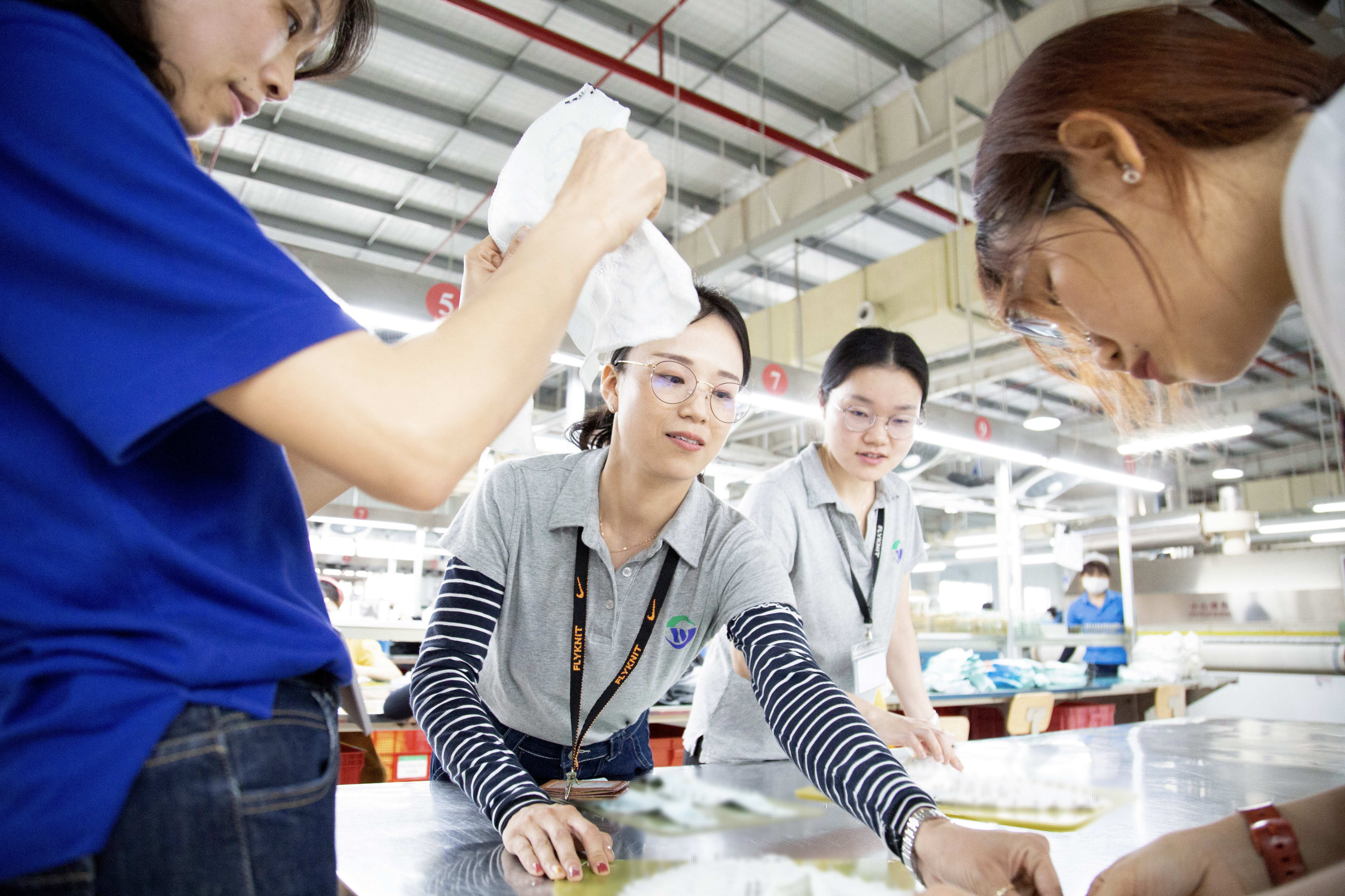 Nike and Shenzhou teammates work together in a facility dedicated to manufacturing Flyknit, one of our most sustainable innovations.