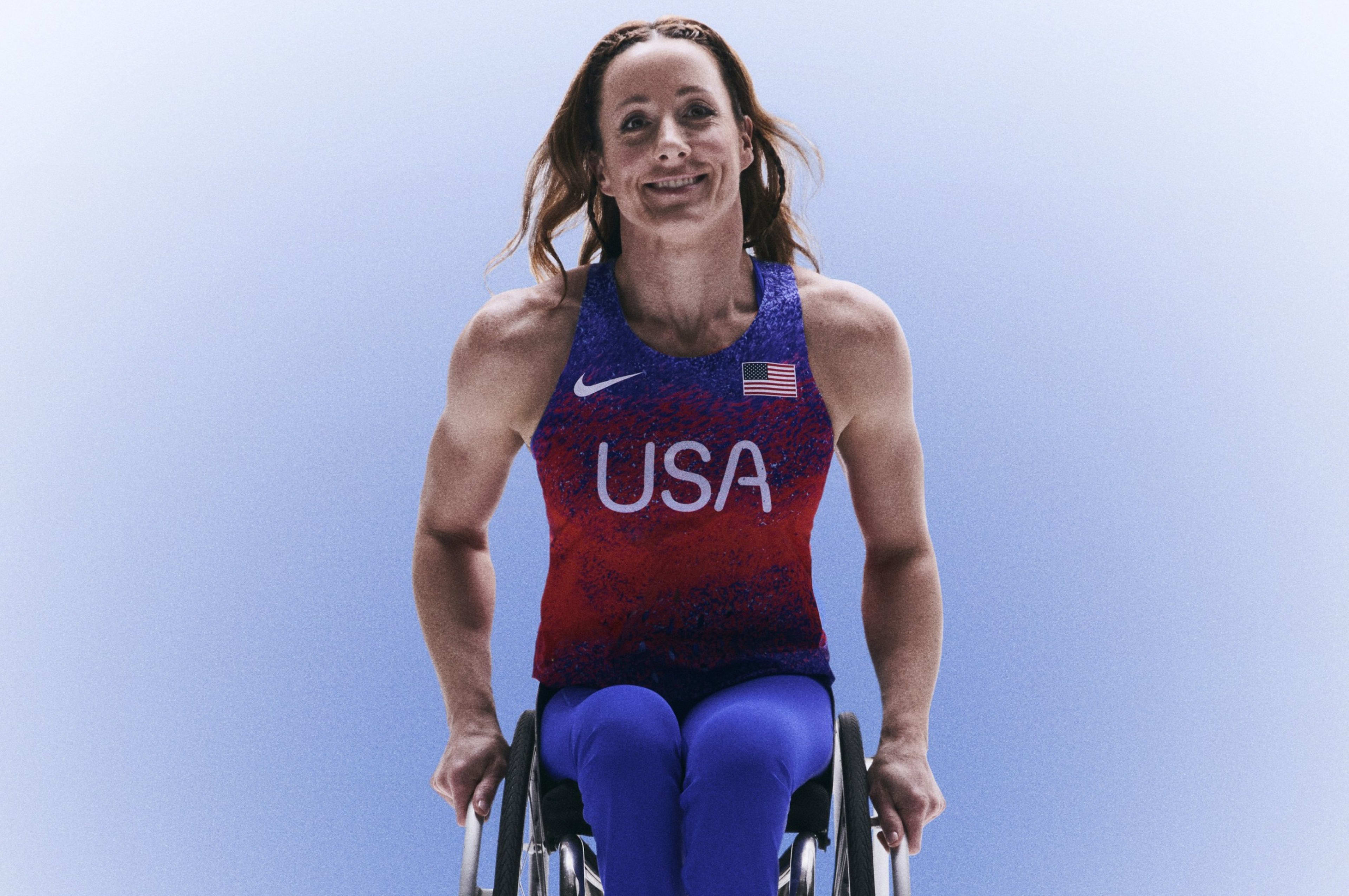 Tatyana McFadden smiling in her wheelchair while wearing her USA track and field kit uniform.