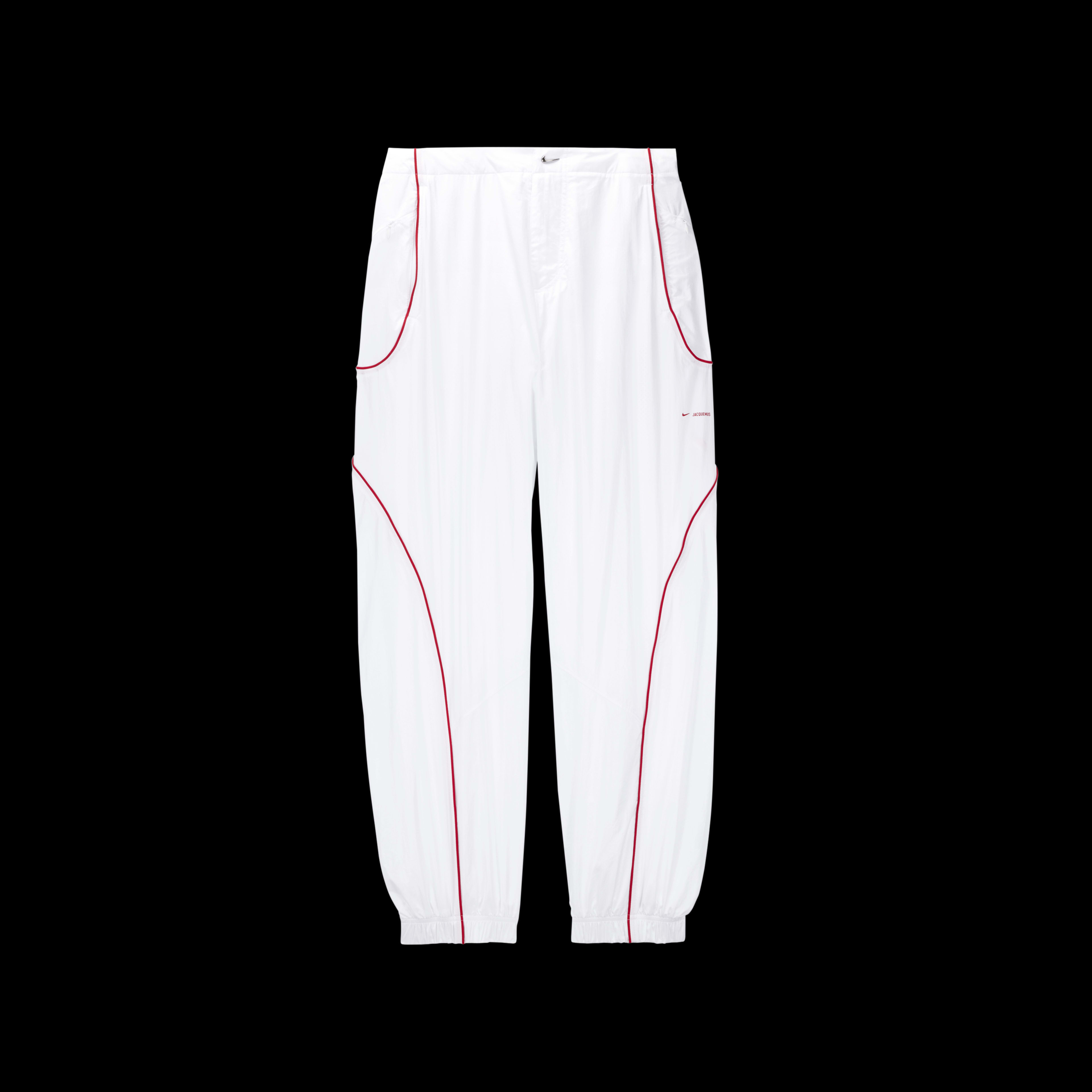 Overhead view of the Nike x Jacquemus Track Pant in white with curved university red pinstripes at the pocket and down the leg.  There is a small shiny silver swoosh as a closure on the waist, and elastic cuffs at the ankle. The pant floats on a black background.