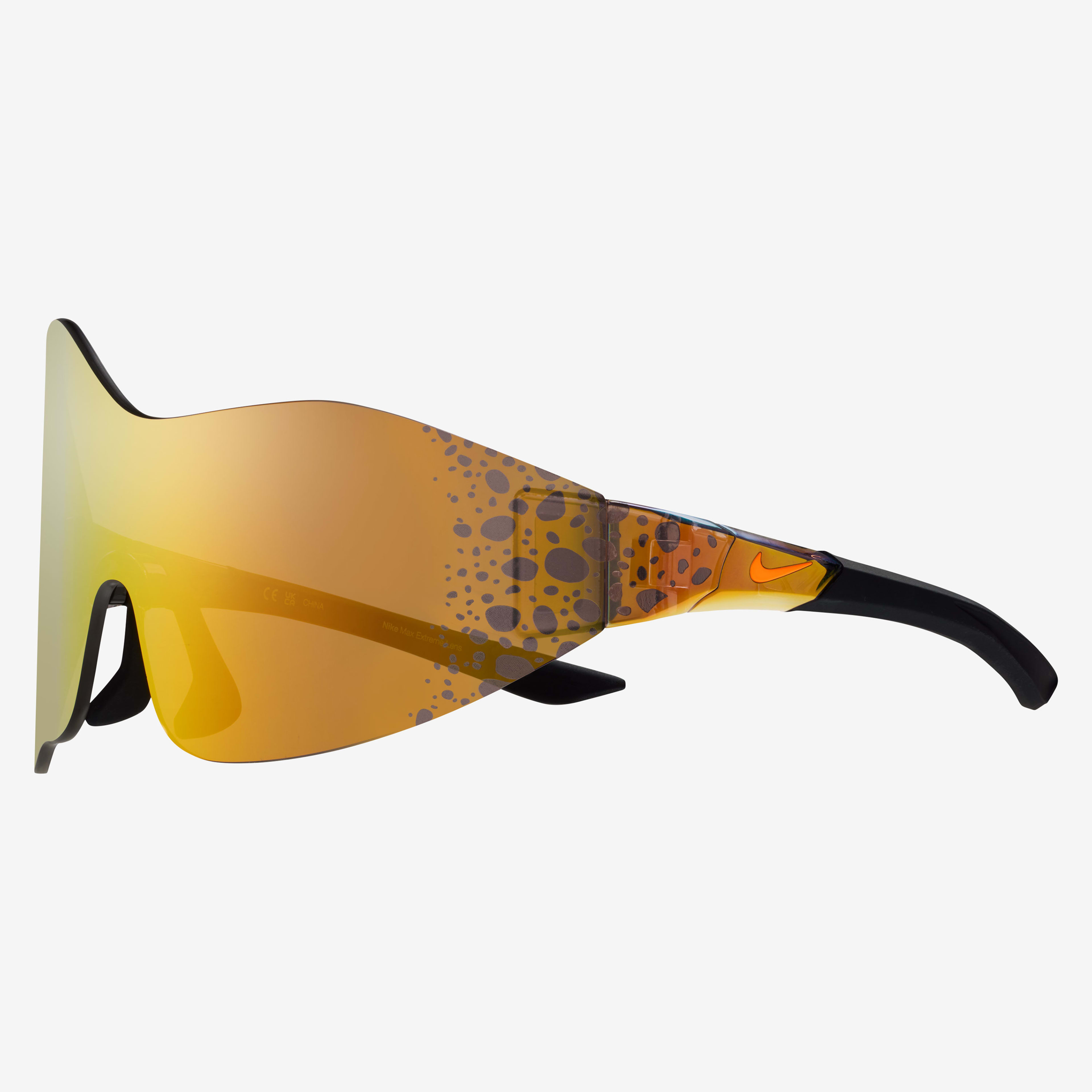 Side view of the Nike Athena sunglasses, showcasing the wrapping asymmetrical mirrored orange lens with Electric graphic at the temples. Electric graphic is a pattern of brown/black speckled spots.   Glasses float on a white background.