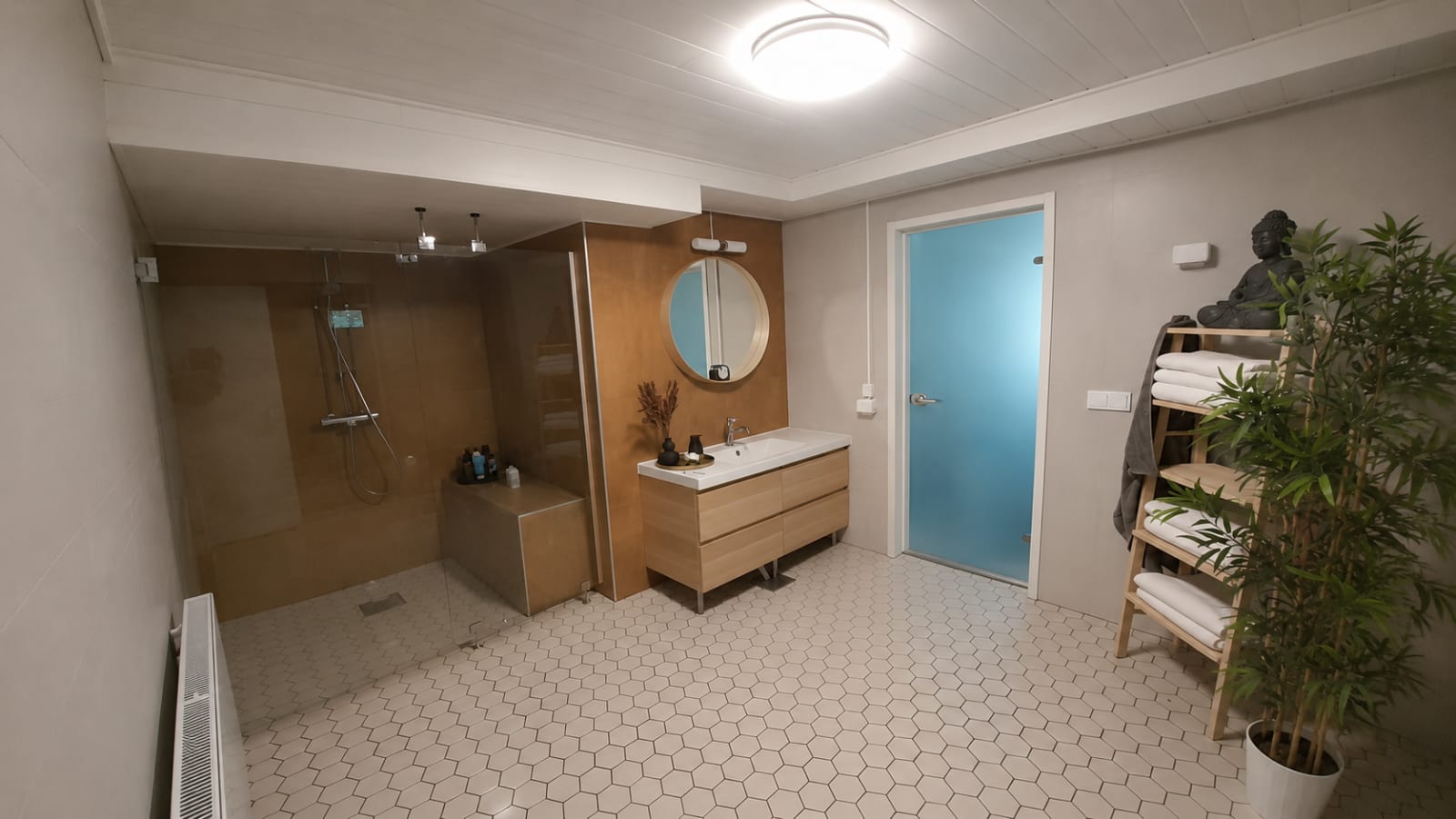 Vaalea laatoitettu kylpyhuone, suihkutila ja lasiovinen sauna — märkätilaremontti Tampereella