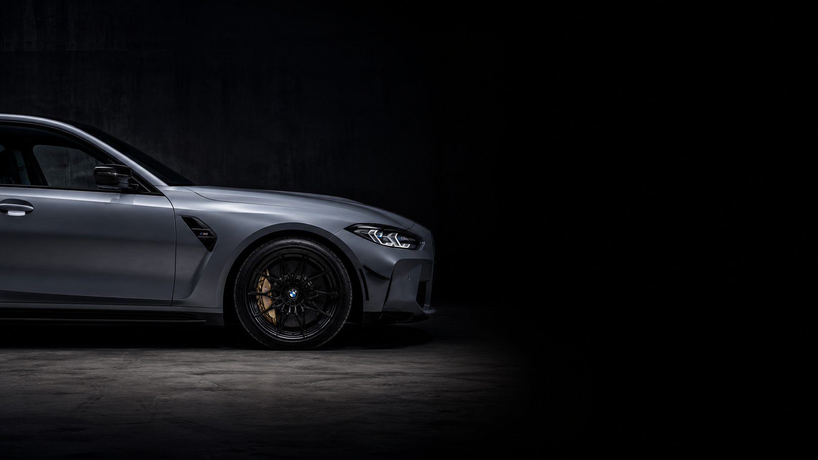 Hopeanharmaa BMW M3 Competition tummassa korjaamohallissa