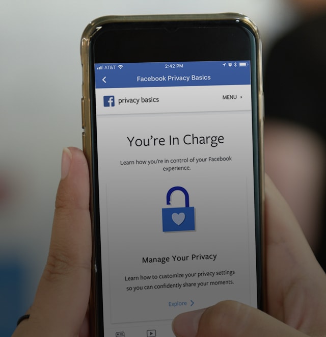 Hand holding a phone showing the facebook app