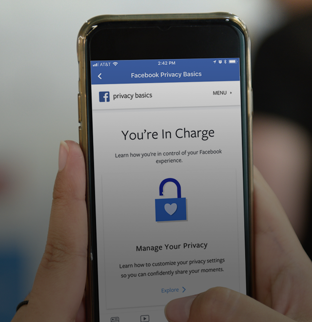 Hand holding a phone showing the facebook app