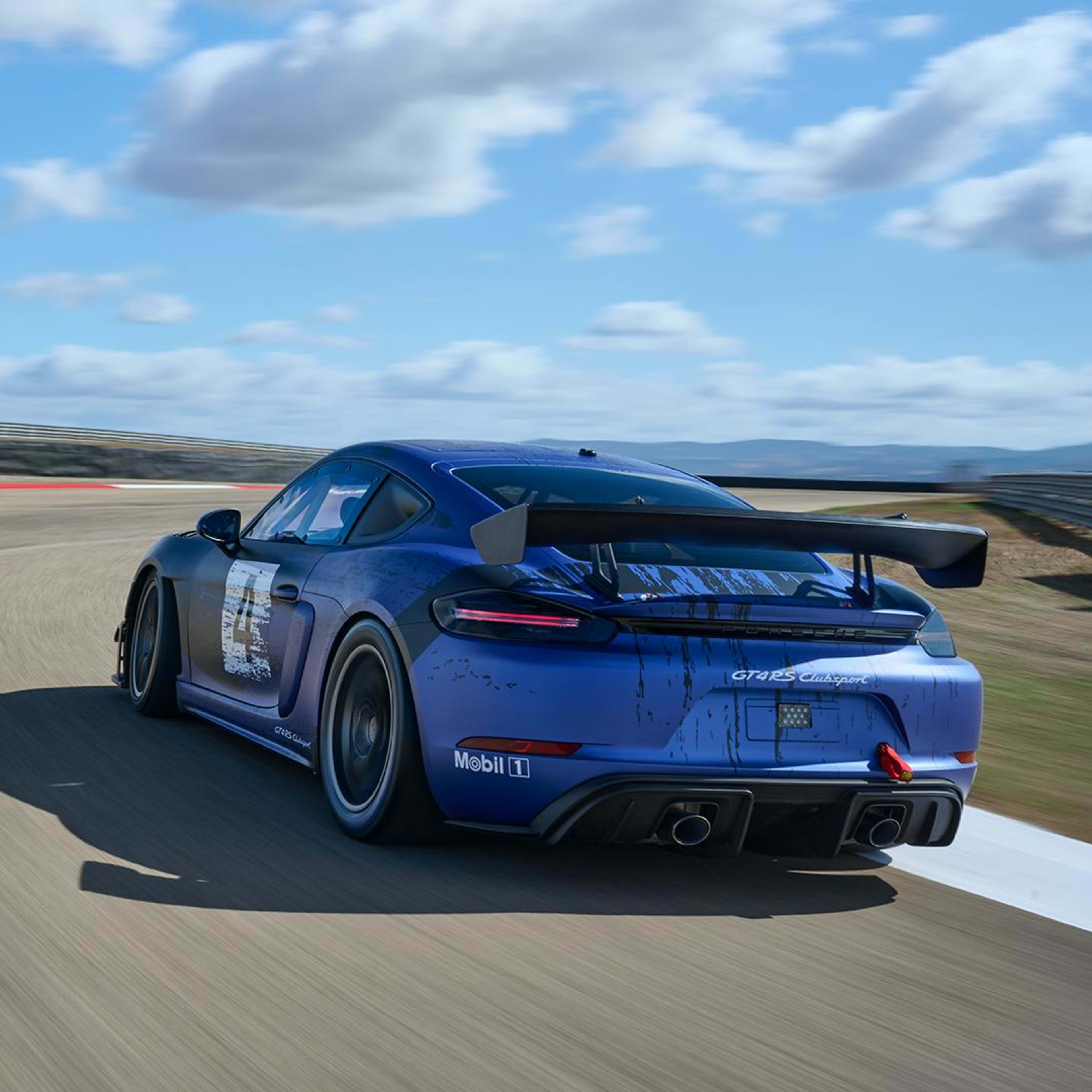 the 718 Cayman GT4 RS Clubsport  driving on the track with blue sky ahead