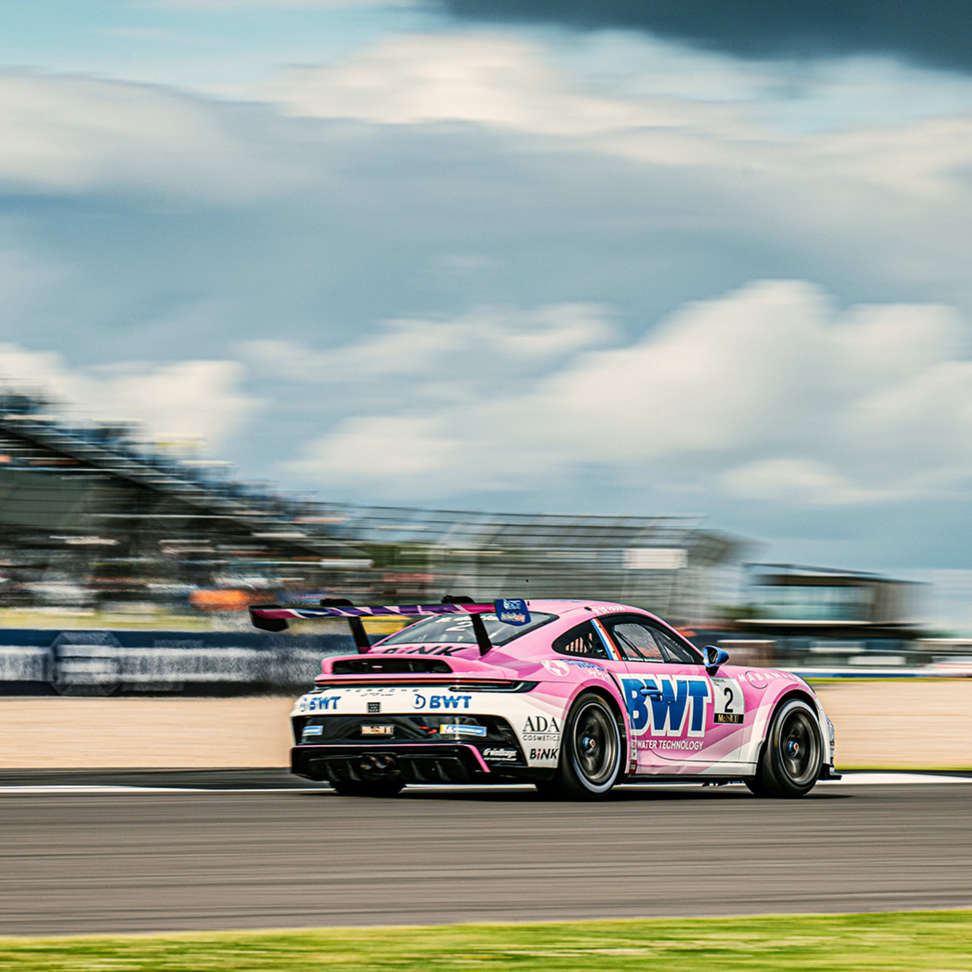 Please add an A pink Porsche 911 GT3 Cup racing car from BWT Lechner Racing shoots across the race track at the Porsche Mobil 1 SupercupAlt text