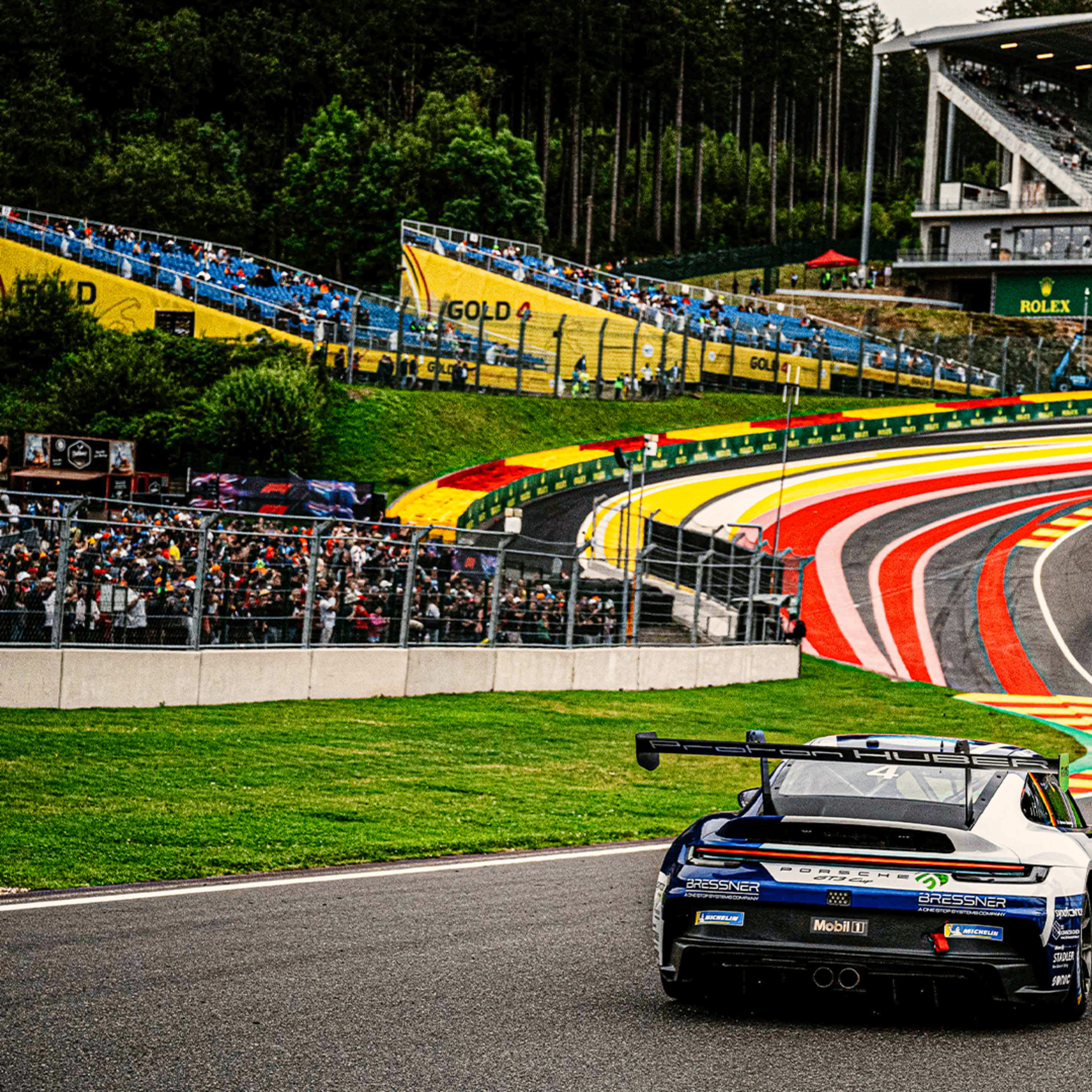 A Porsche 911 GT3 Cup racing car speeding up Eau Rouge corner during the 2024 Porsche Supercup race in Spa-Francorchamps