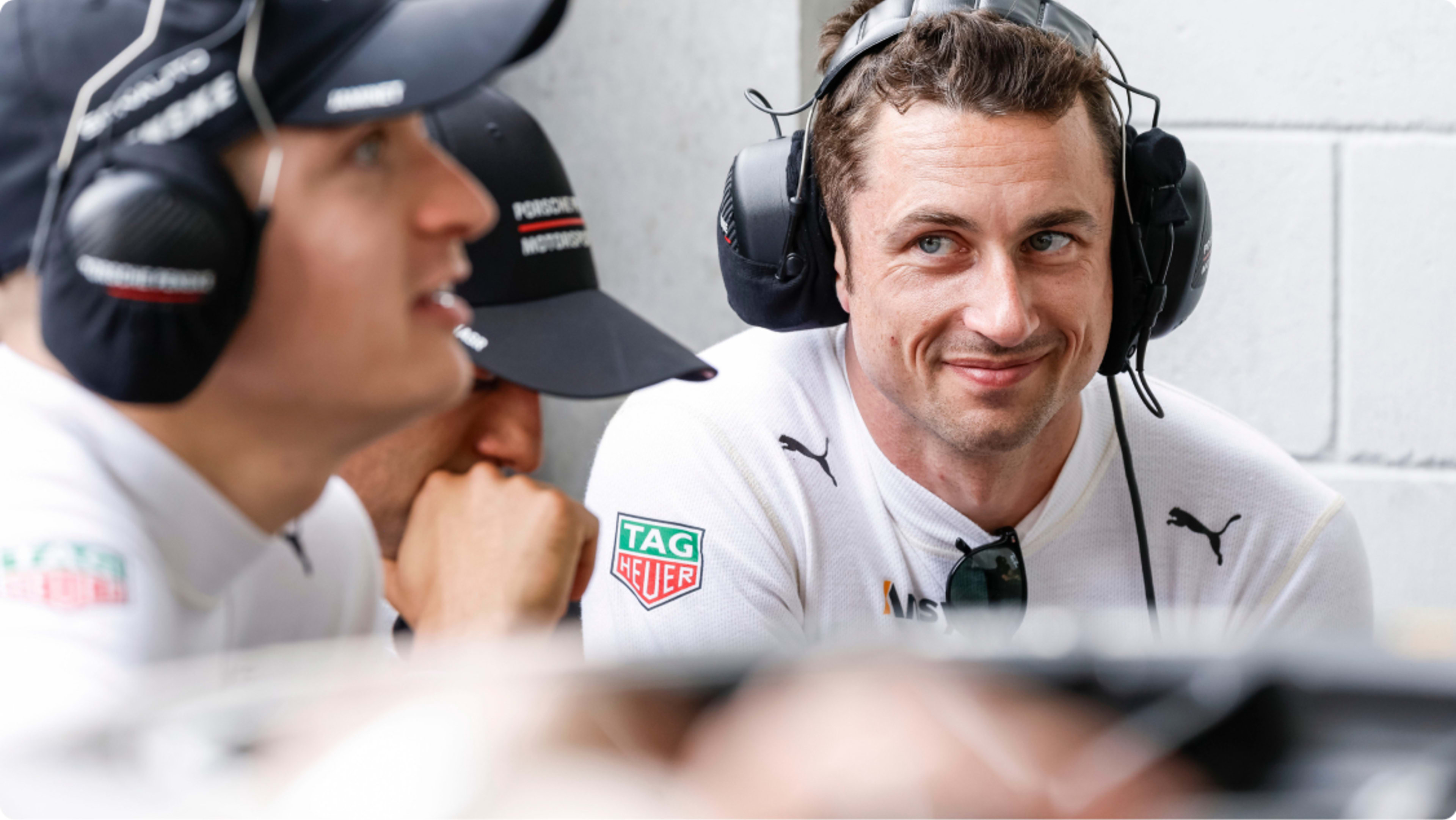 Dane Cameron smiling at his team mate with a headset