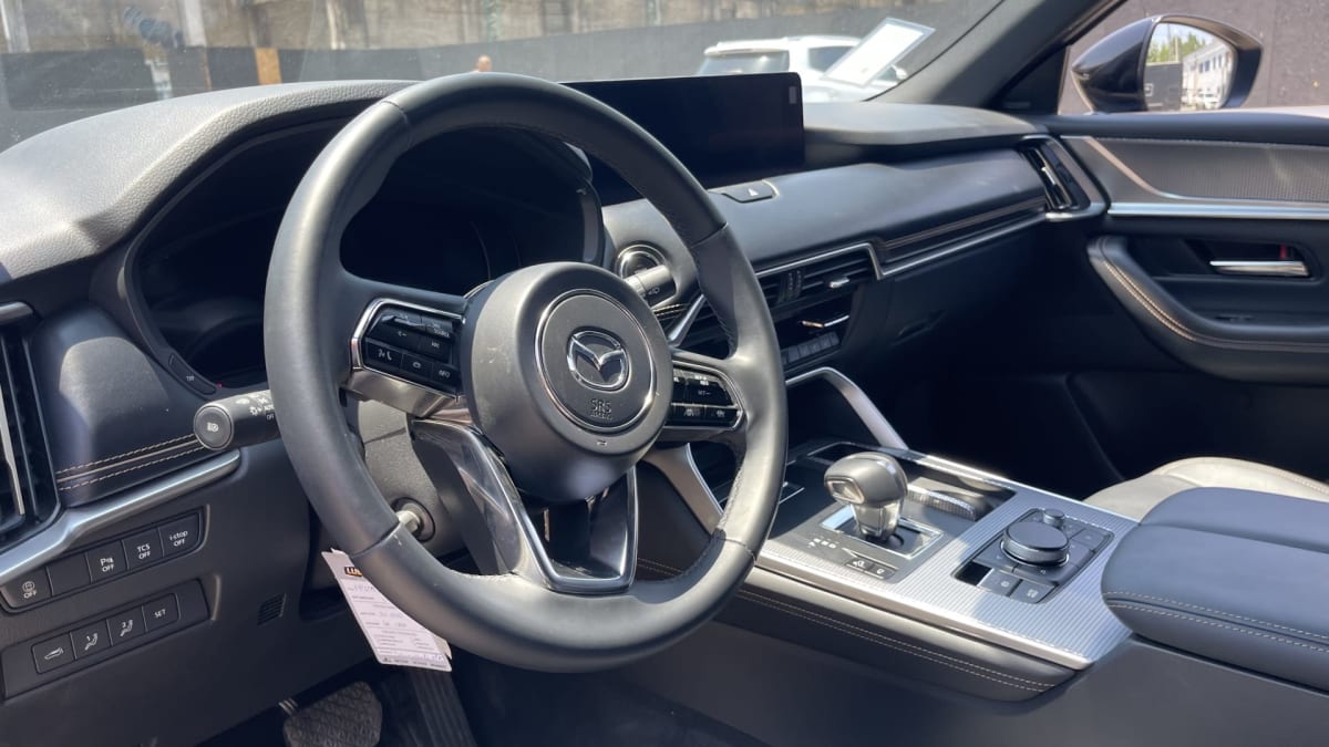 2026 Mazda CX-60 3.0 Diesel Premium Sport Azul - Vista interior, detalle del volante y consola central en interior.