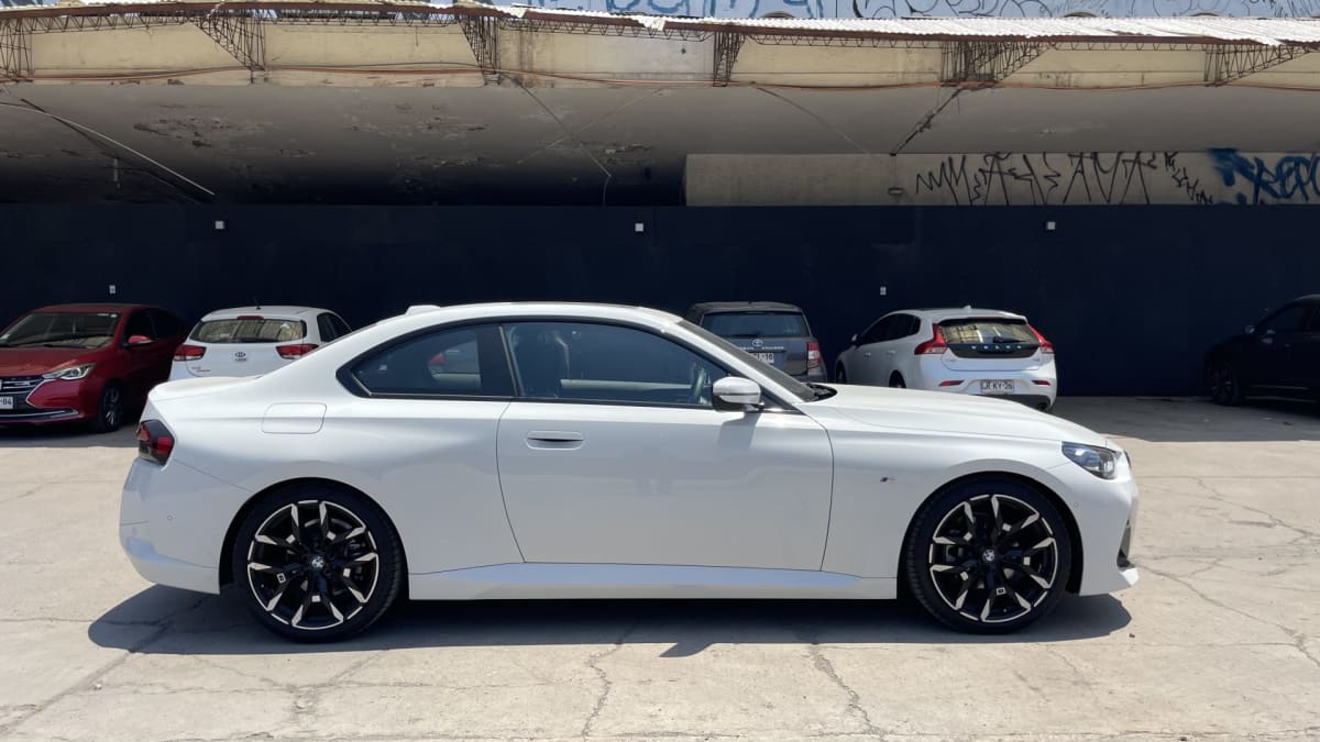 2025 BMW M220 - Vista lateral de coupé color blanco en exterior