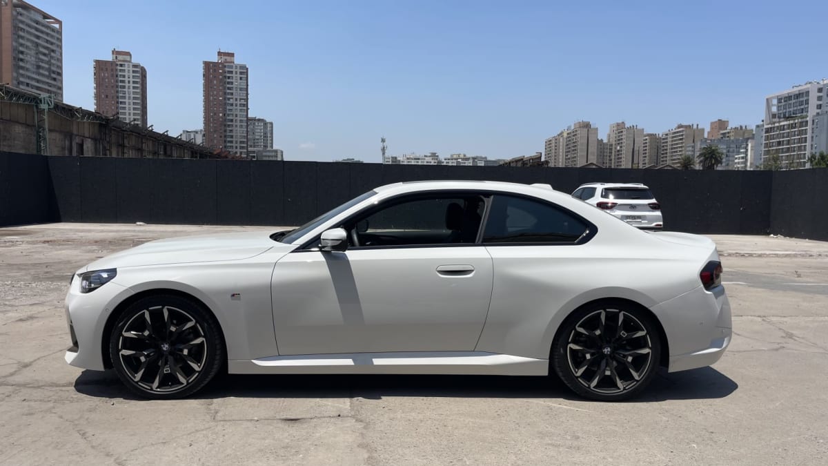 2025 BMW M220 - Vista lateral de coupé color blanco en exterior