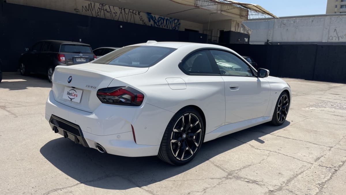2025 BMW M220 - Vista trasera 3/4 de coupé color blanco en exterior