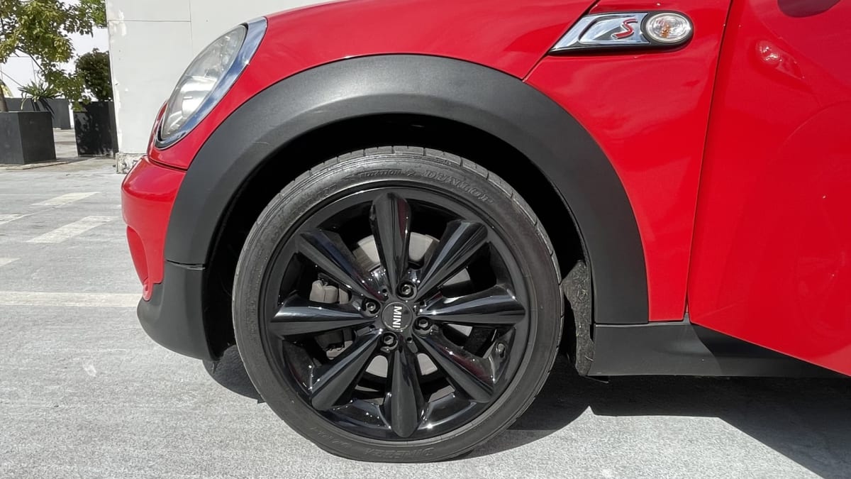 2011 MINI Cooper S R56 Rojo - Detalle de rueda negra y parte frontal de hatchback rojo en exterior