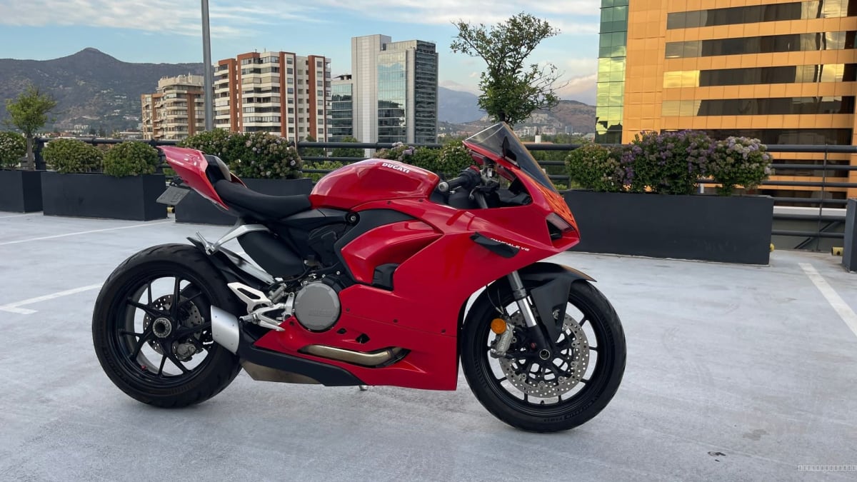 2021 Ducati Panigale Rojo - Vista lateral 3/4 de motocicleta roja en exterior con edificios de fondo