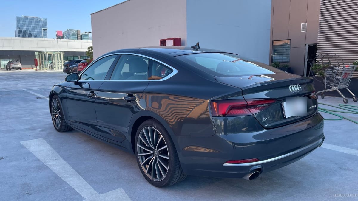 2020 Audi A5 Gris - Vista trasera 3/4 de sedán color gris oscuro en estacionamiento exterior