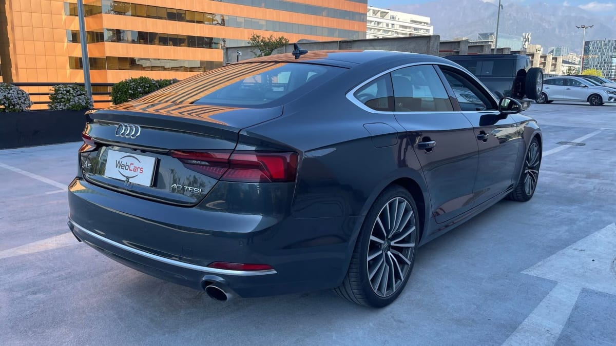 2020 Audi A5 Gris - Vista trasera 3/4 de sedán color gris oscuro en estacionamiento exterior