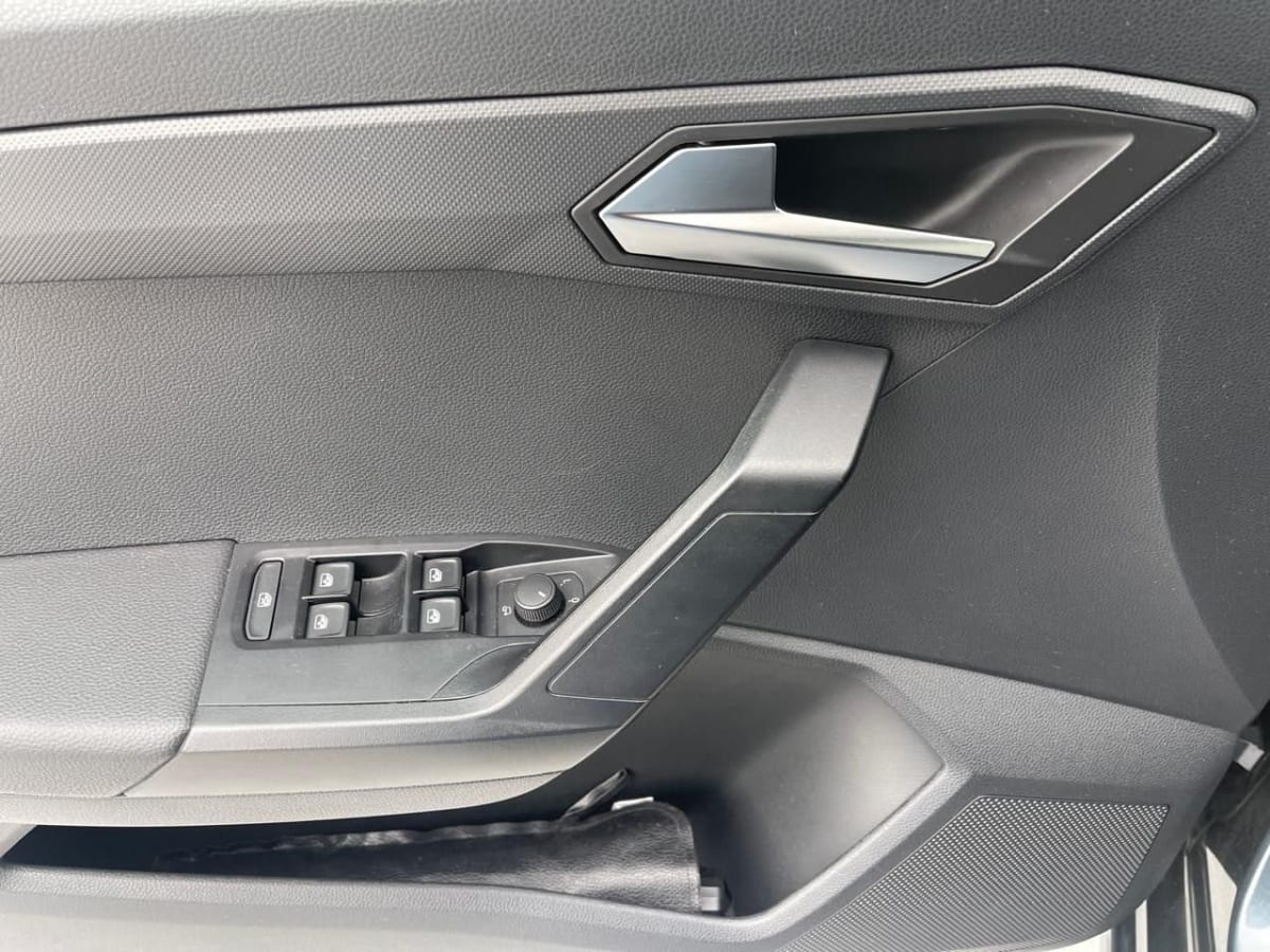 Seat Ibiza 2024 Style AT: Hatchback Gris, 16.000 km - Detalle interior de puerta color negro con controles de ventanas y manilla cromada