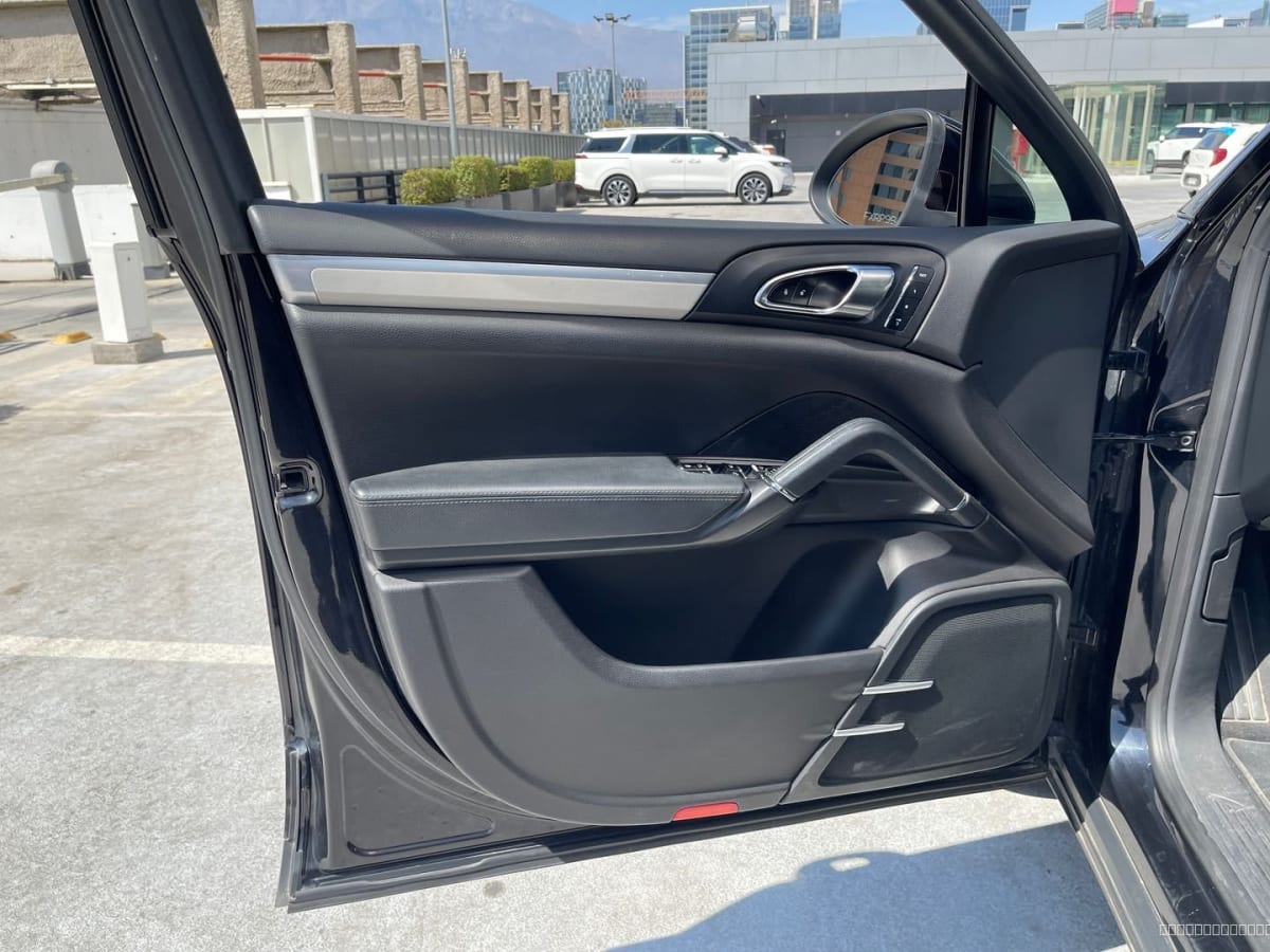 2013 Porsche CAYENNE V6 E2 Negro - Detalle de puerta interior color negro de SUV en estacionamiento exterior